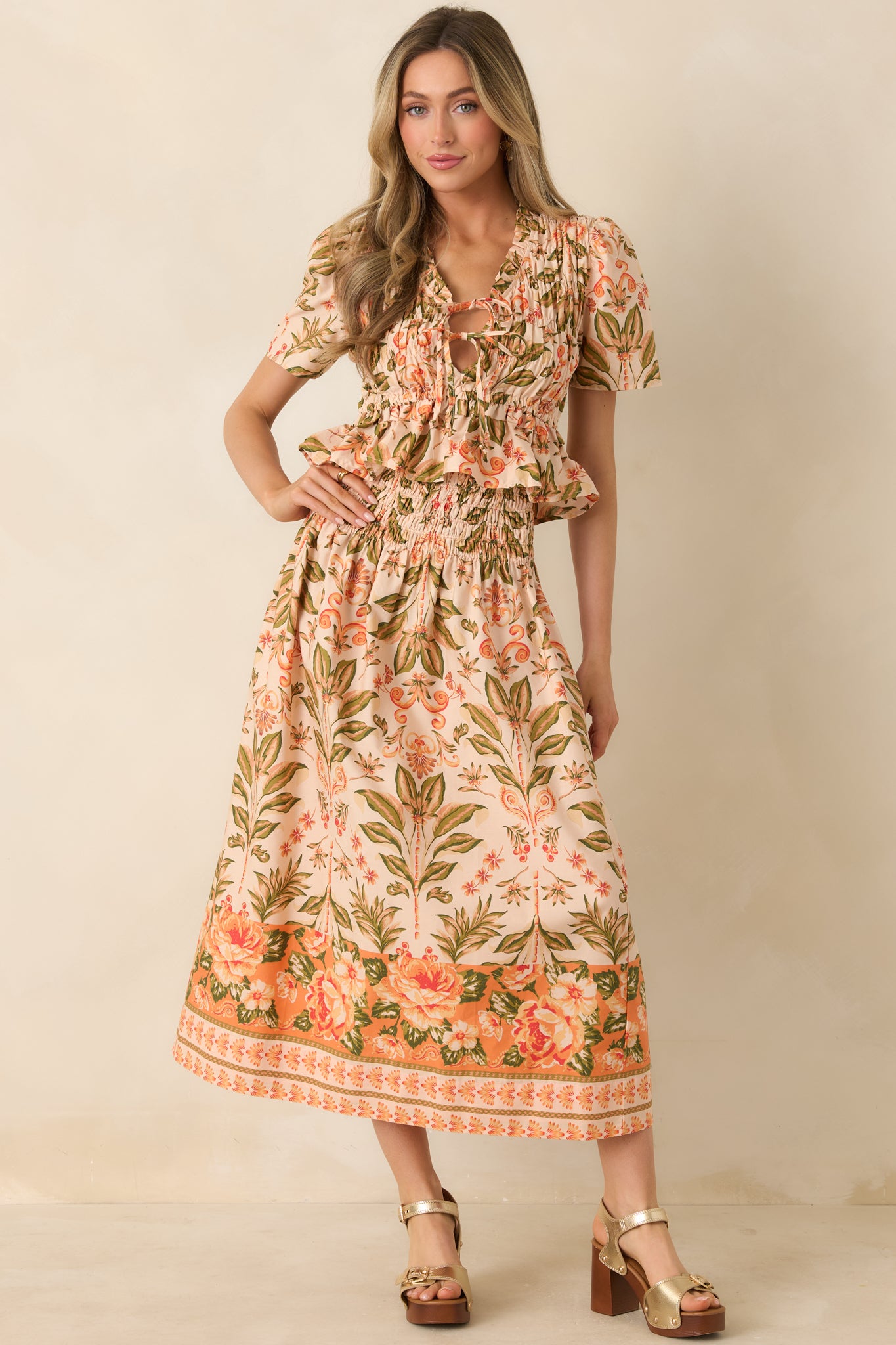 Lightweight midi skirt with peach tones, green accents, and statement hem border.