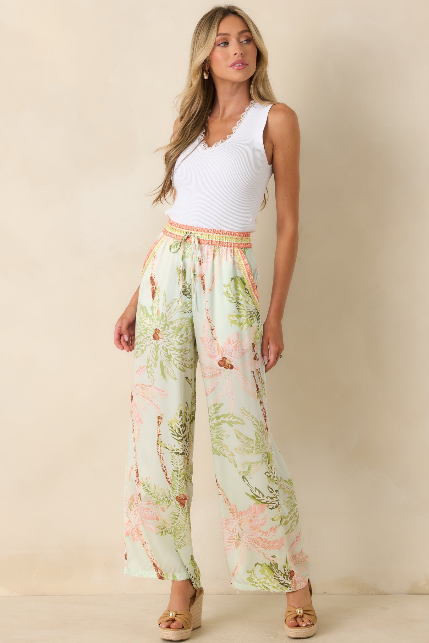 Lightweight resort-style pants showcasing a flowy wide-leg shape with an adjustable drawstring waist and soft tropical tones.
