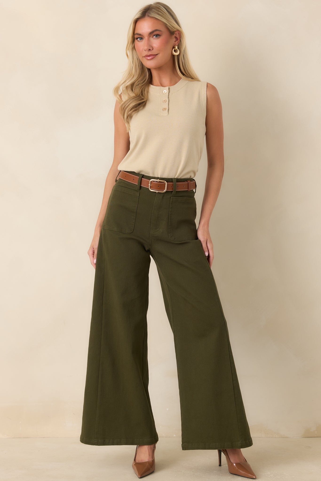 Lightweight sleeveless knit top featuring a classic crew neck, functional three-button detail, and a clean ribbed hem for a polished look.