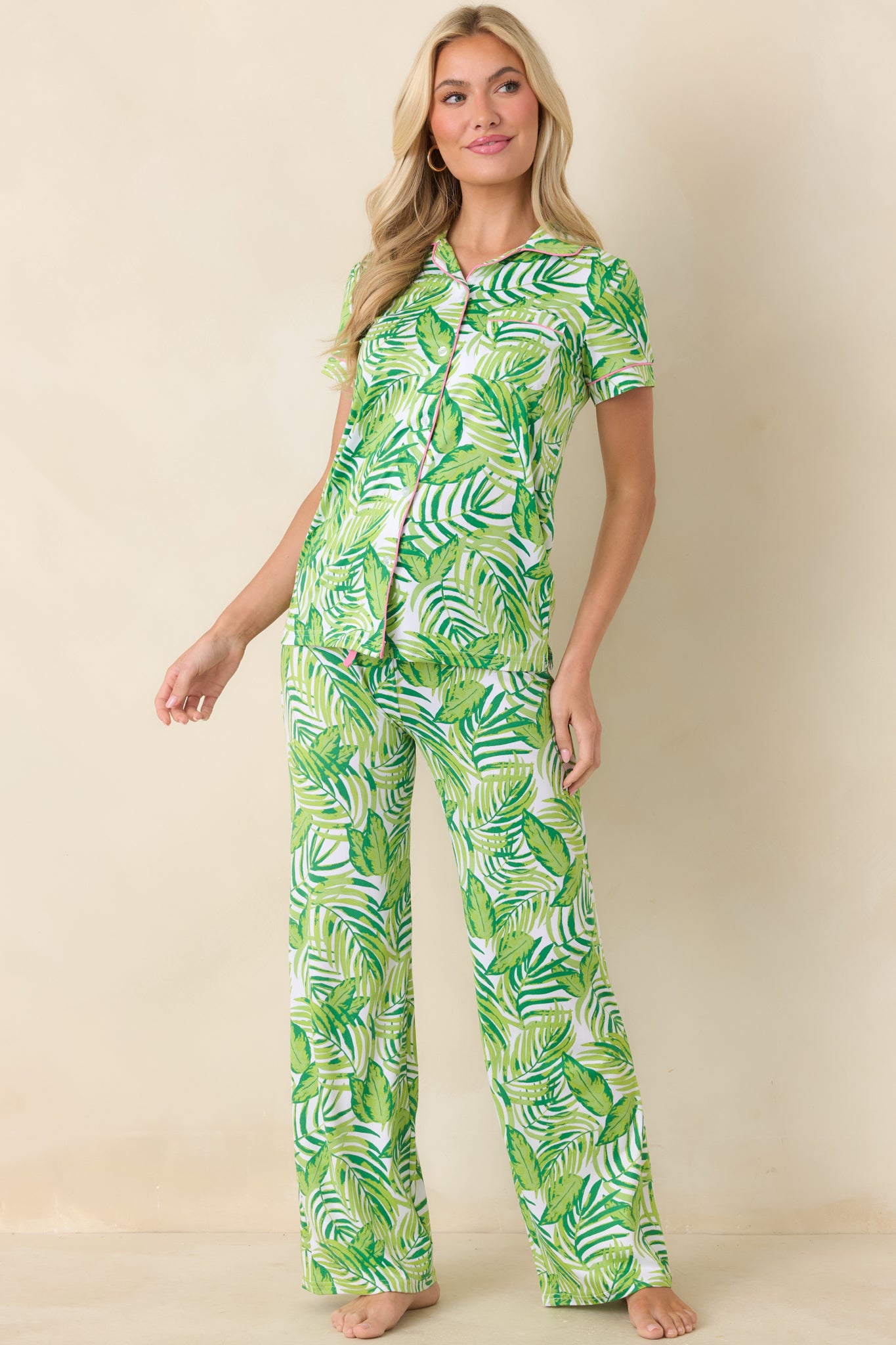 Lightweight tropical print top featuring contrast pink piping, front chest pocket, and breathable silhouette
