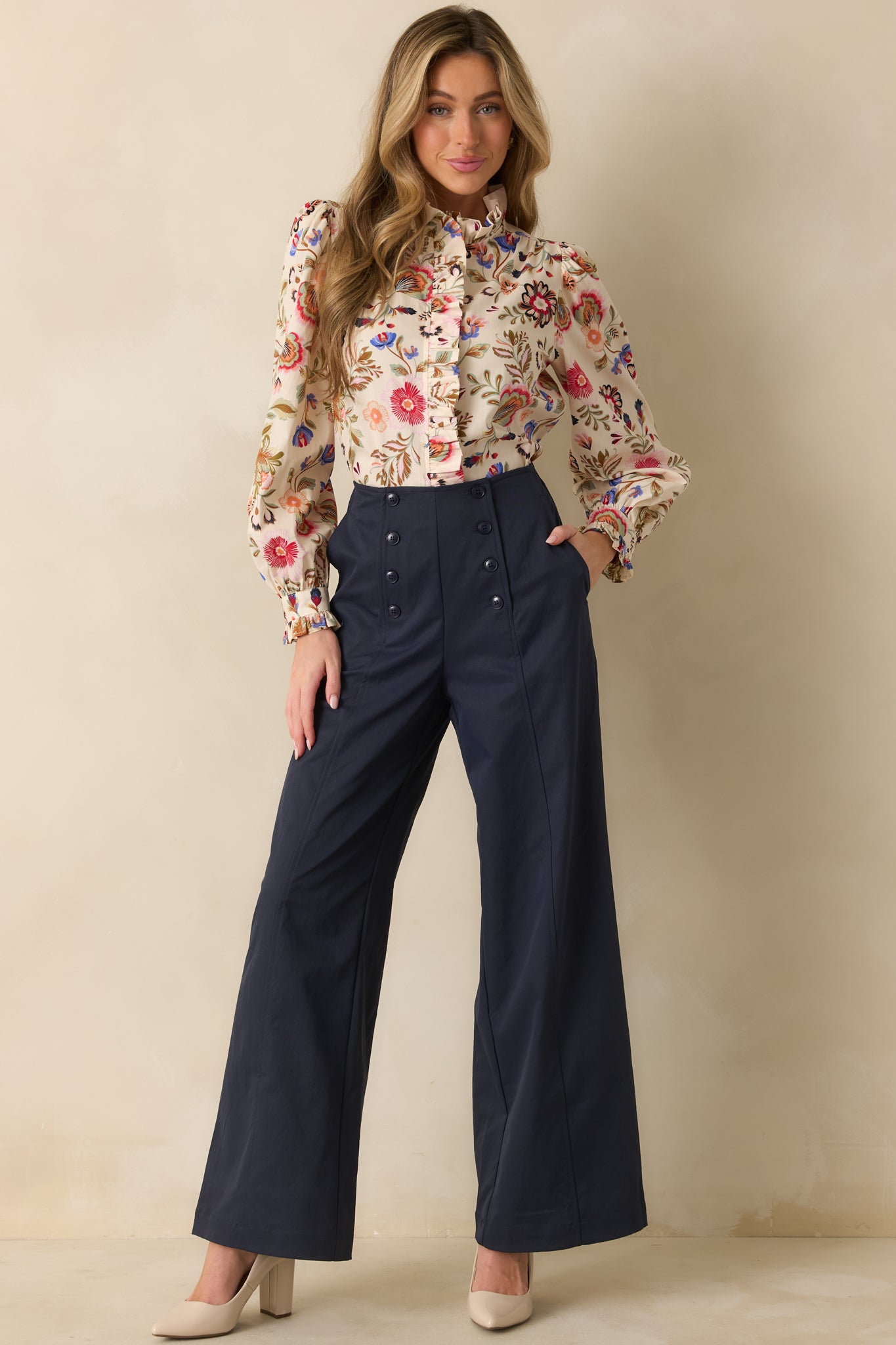 Lightweight woven ivory top with puffed long sleeves, ruffled neckline, and polished floral pattern.