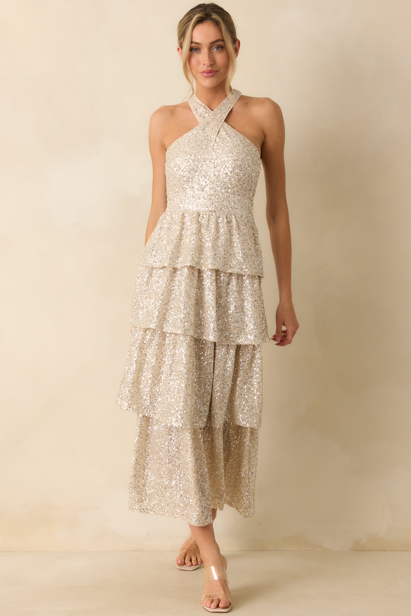 Long champagne sequin dress with a body-skimming silhouette and sparkling layered skirt.