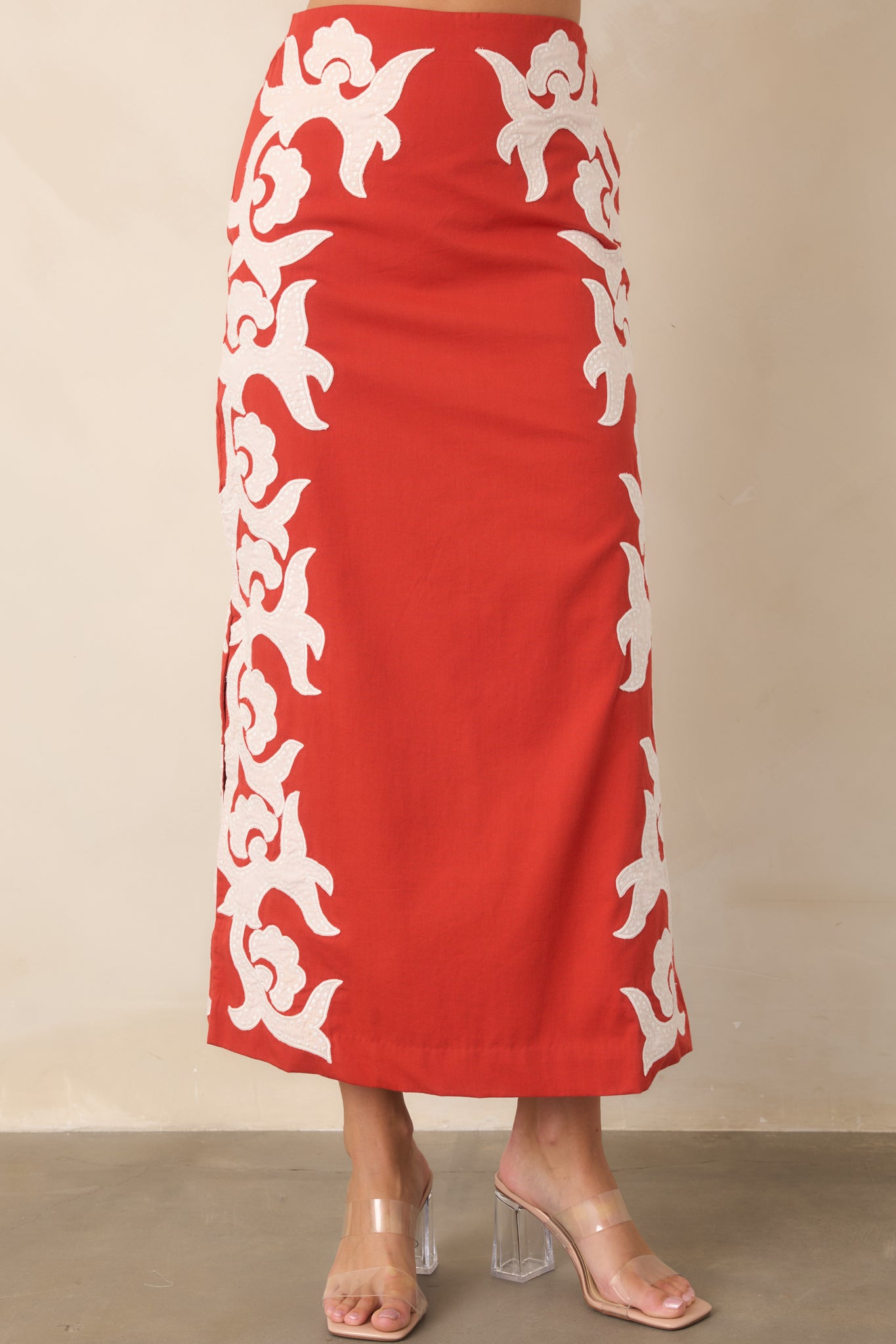 Long midi silhouette highlights the skirt's structured column shape and distinctive ivory appliqué detailing.