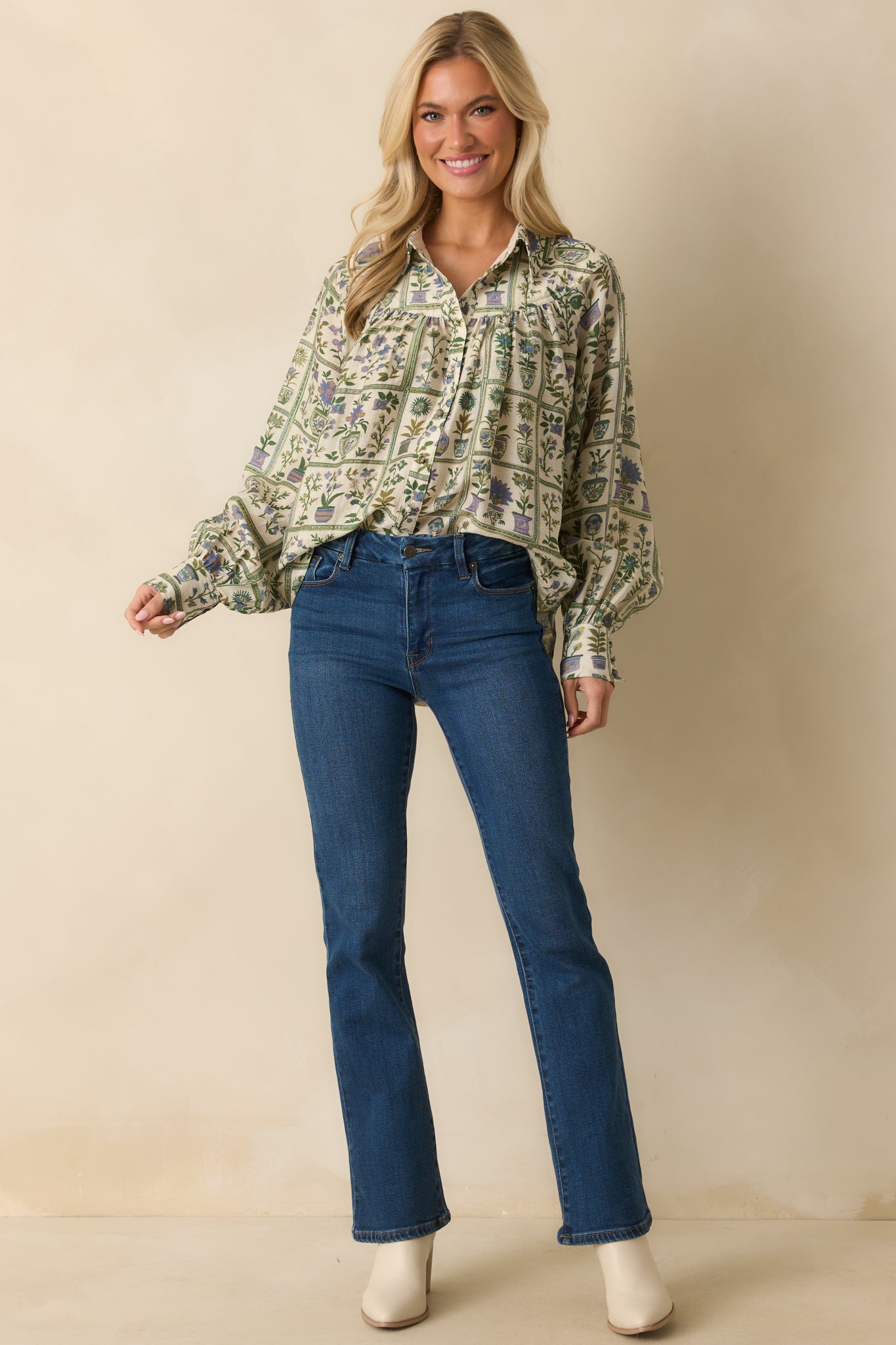 Relaxed-fit long sleeve blouse patterned with small multicolor flowers and a classic collared design.