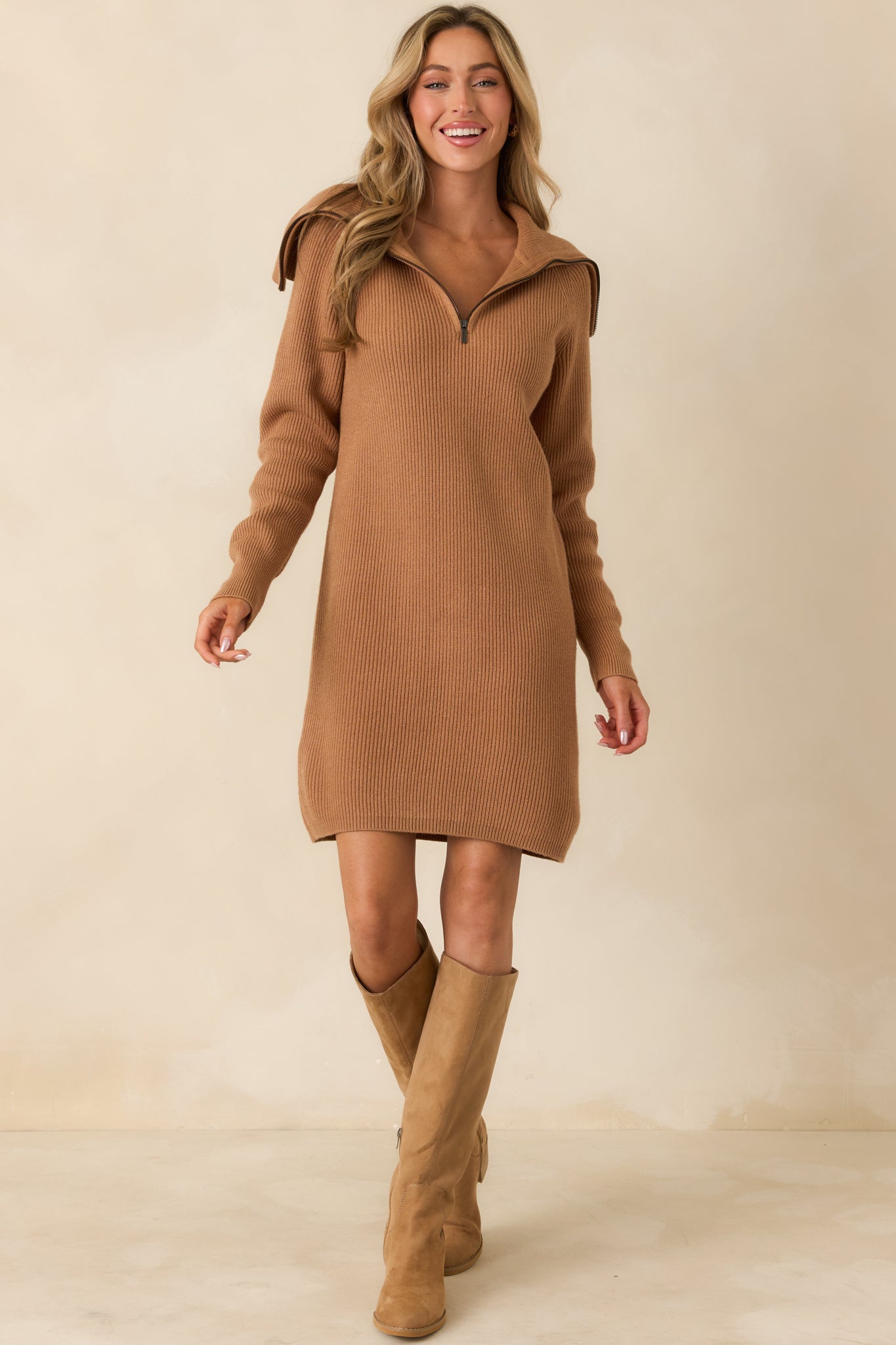 Long-sleeve camel sweater dress with zip-up funnel neckline and relaxed fit.