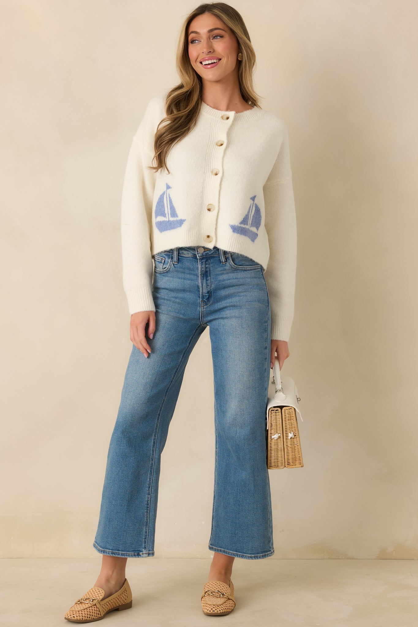 Long-sleeve ivory cardigan buttoned, showing ribbed trim at cuffs, hem, and neckline.