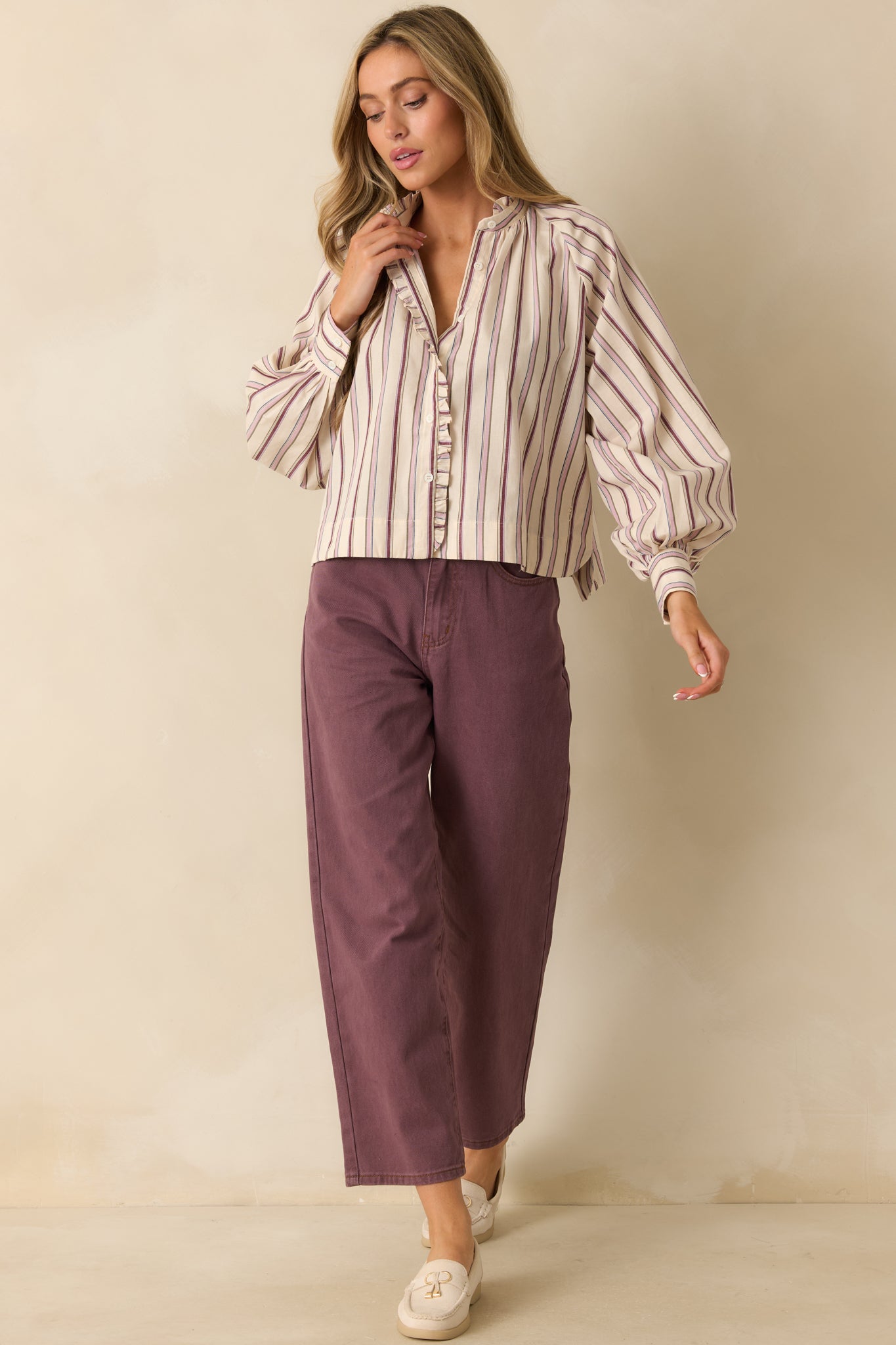 Long-sleeve striped shirt with balloon cuffs and curved hemline, emphasizing the airy, relaxed fit.