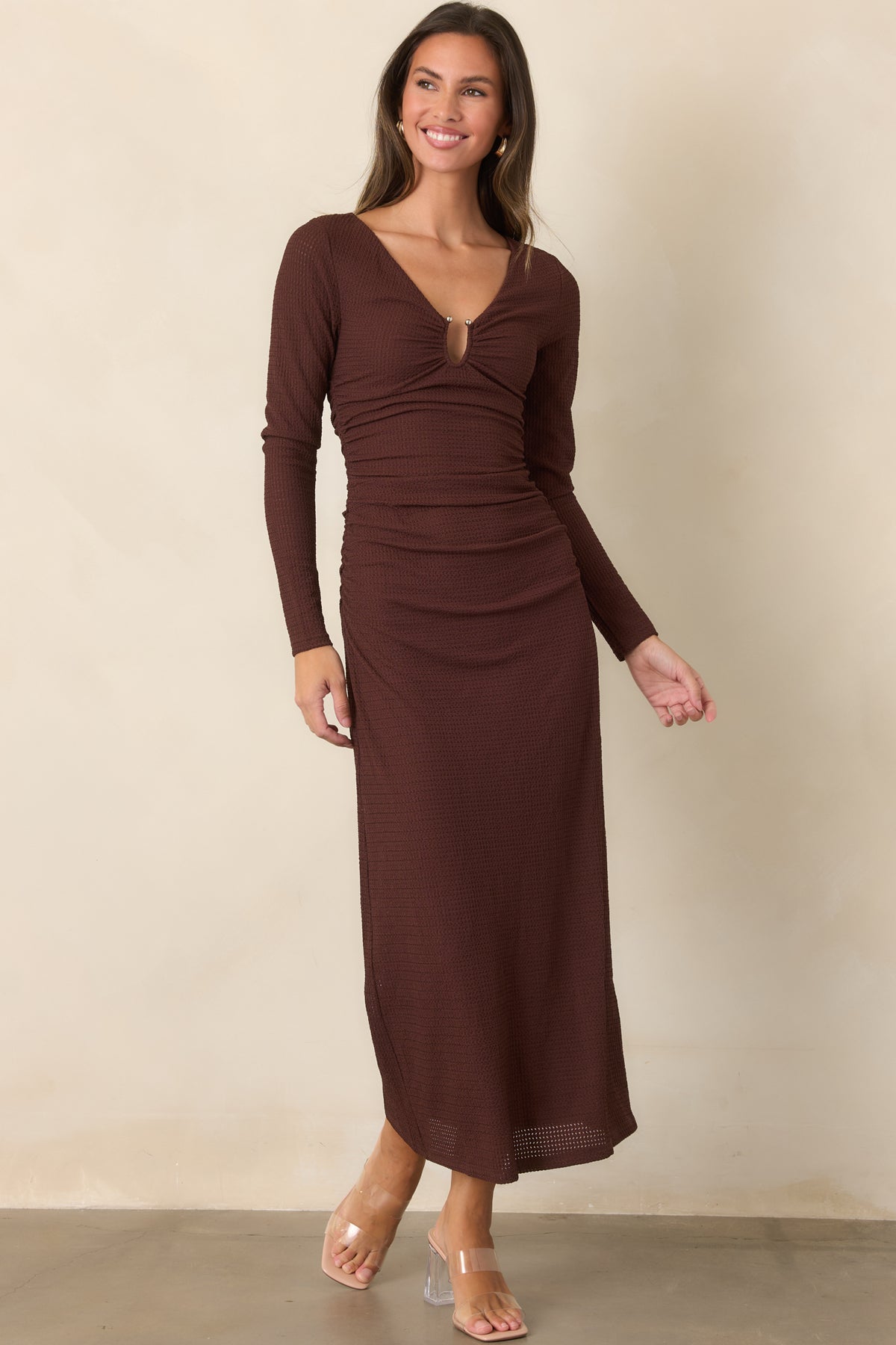 Long-sleeve midi dress combines dimensional textured fabric with a ruched bodice and gently draped skirt silhouette.