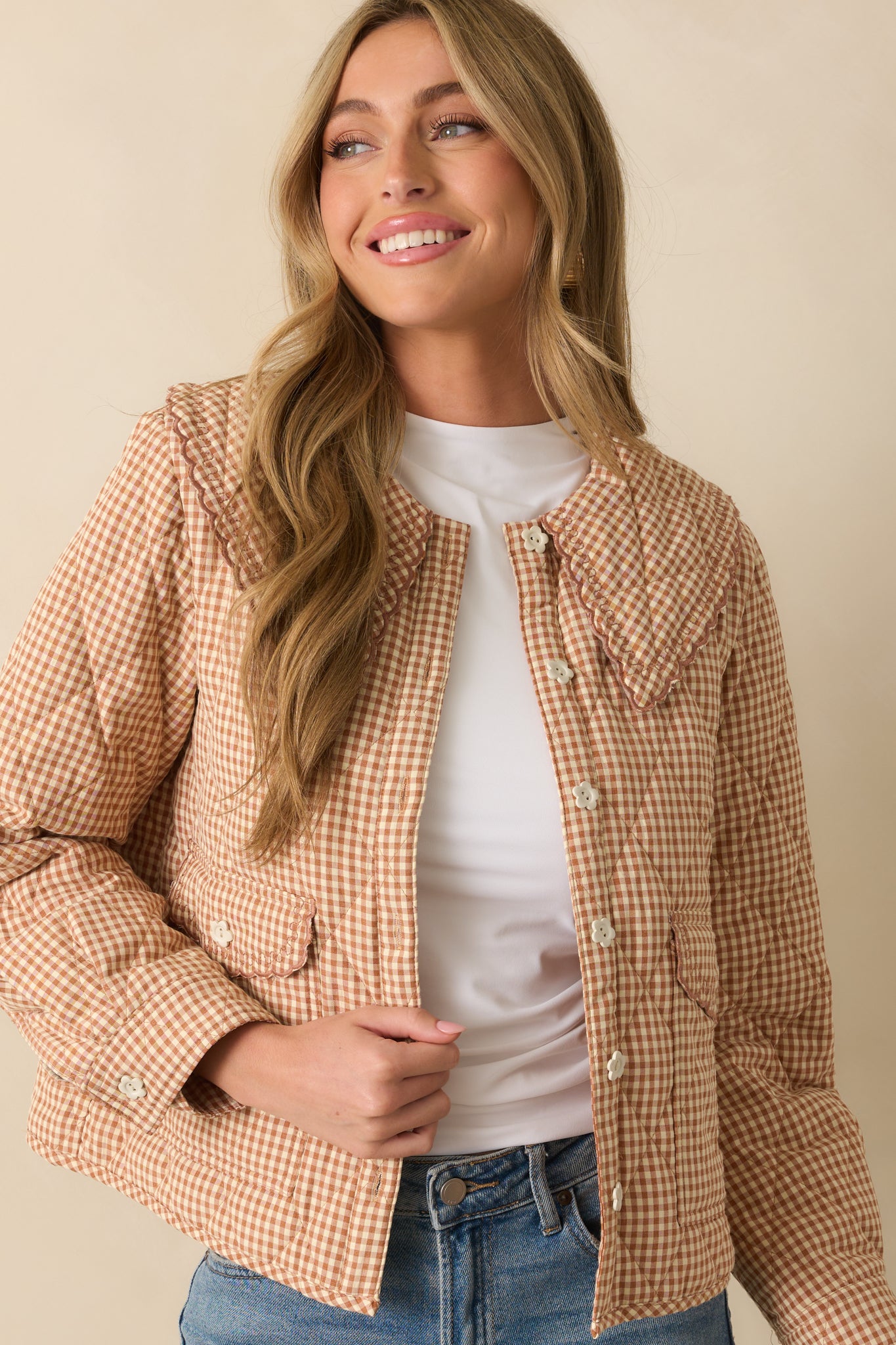 Detail of long sleeves with button cuffs on the light rust gingham jacket.