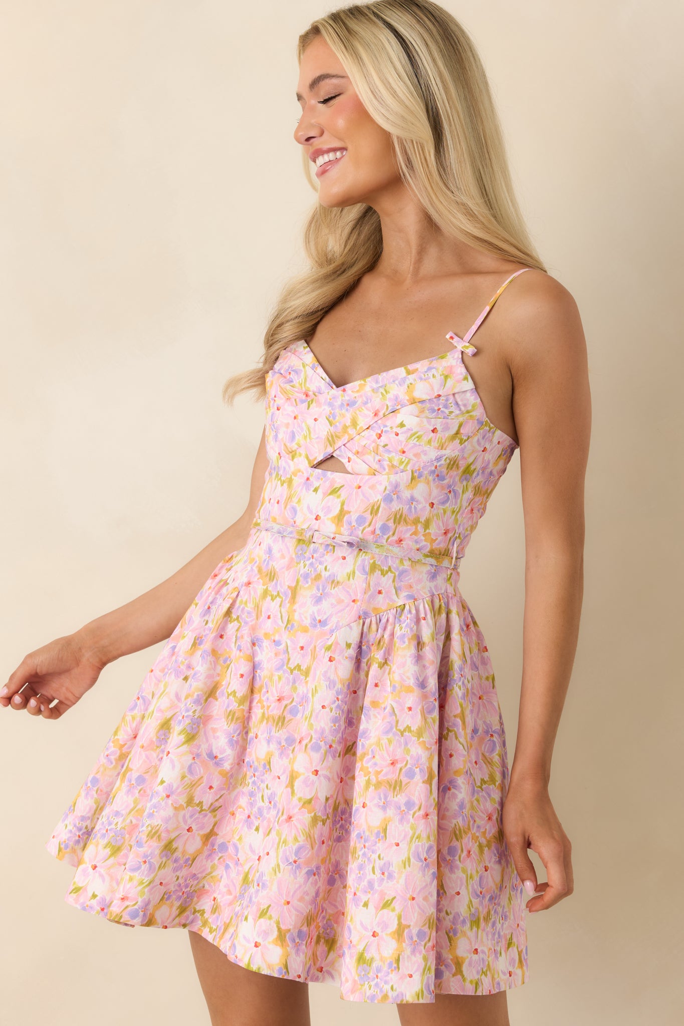 Detailed look at the adjustable spaghetti straps with bow accents on the pink cotton dress.
