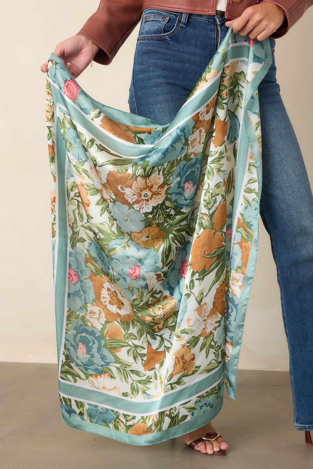 Close view of the softly lustrous fabric, painterly blooms, leafy green details, and bright pink accents.