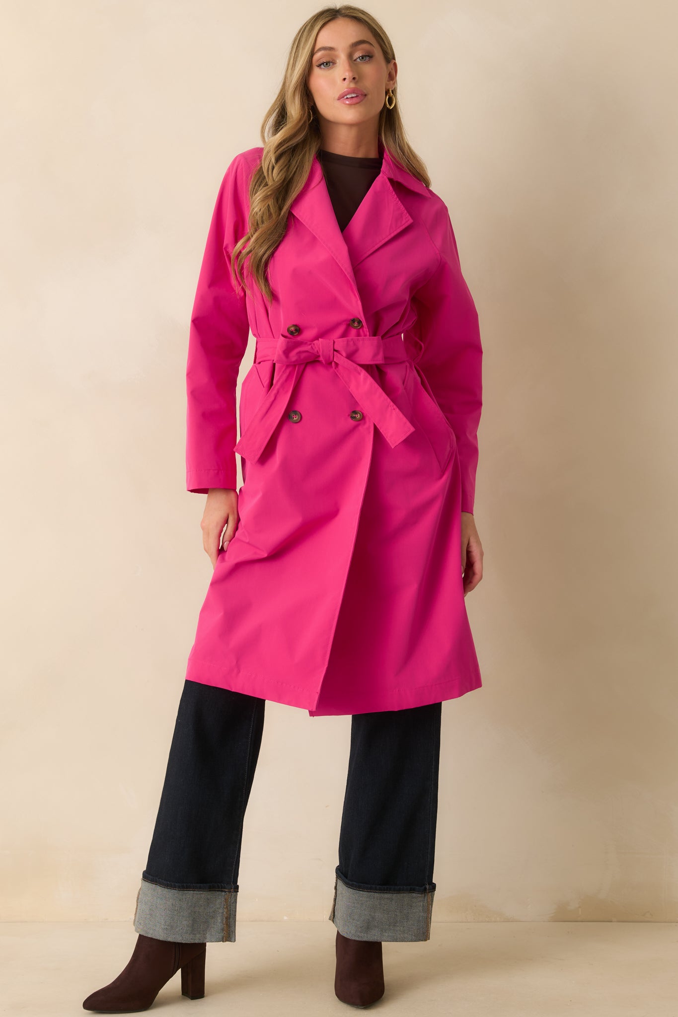 Another full-length shot of the magenta trench coat showcasing its collared neckline, double-breasted lapel, and long sleeves.