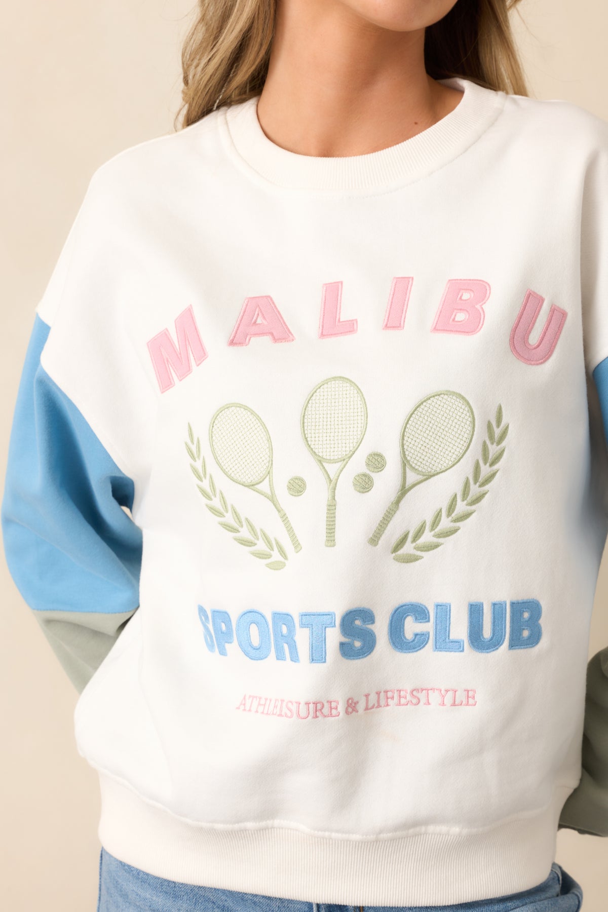A closer view of the "Malibu Sports Club" embroidered graphic and the colorblocking detail on the sleeves, adding a fun, athletic touch.