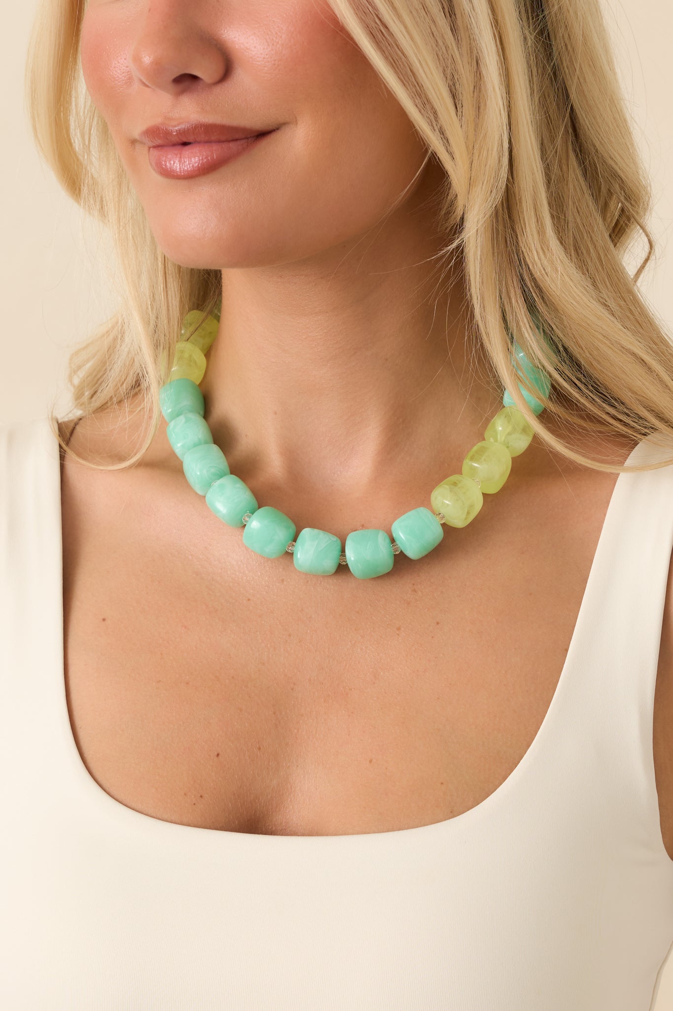 Marbled aqua and light green resin bead necklace featuring clear spacer accents and a bold layered design.