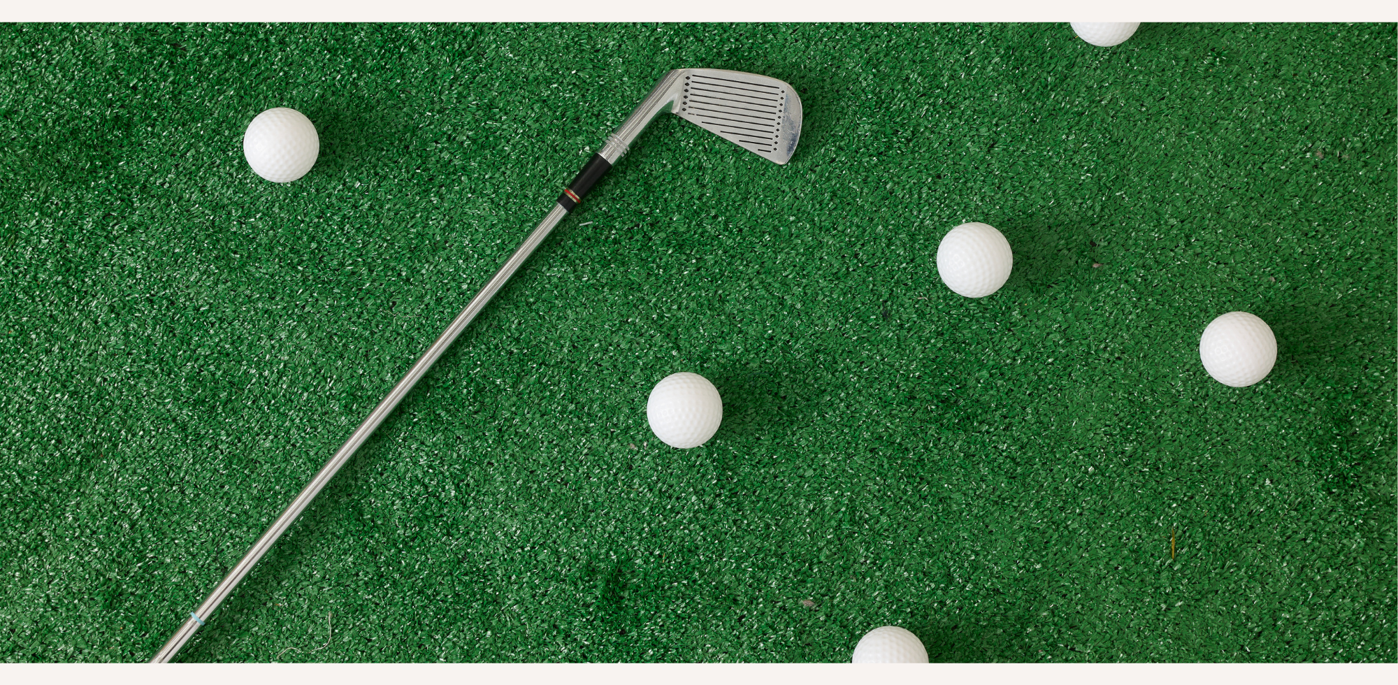 Golf club and balls on a green surface