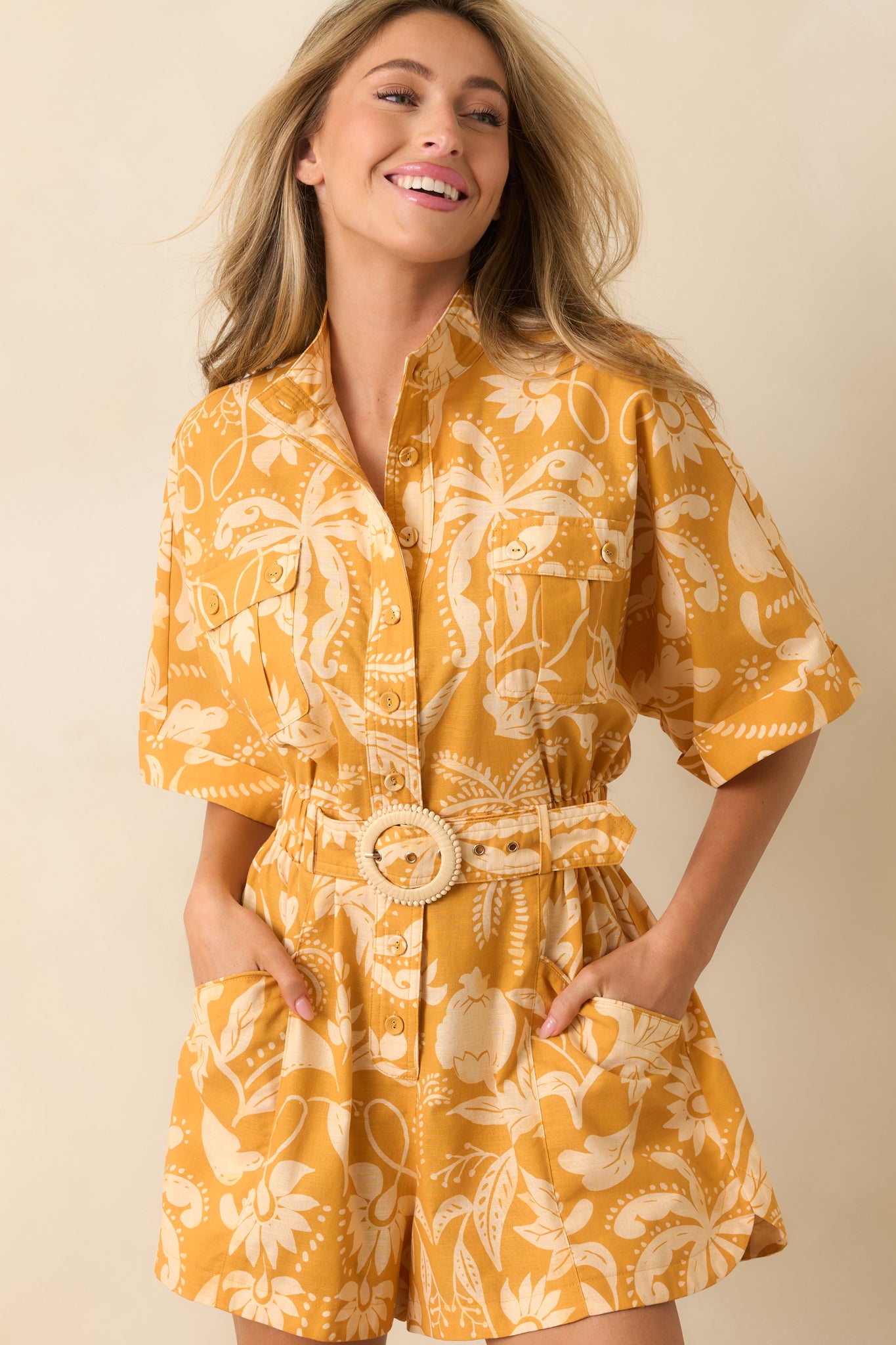 Close view of the marigold and ivory botanical print with relaxed short sleeves and tailored button-front details.
