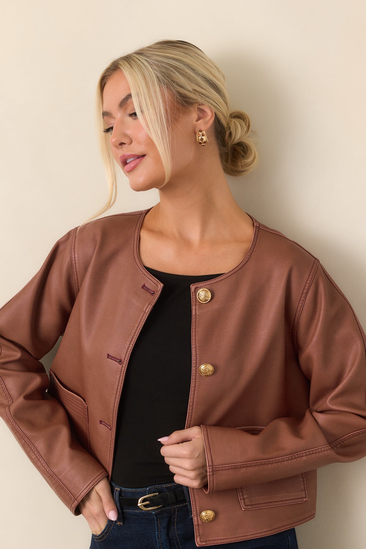 Mauve faux leather jacket highlighting the round neckline and embossed gold front buttons.