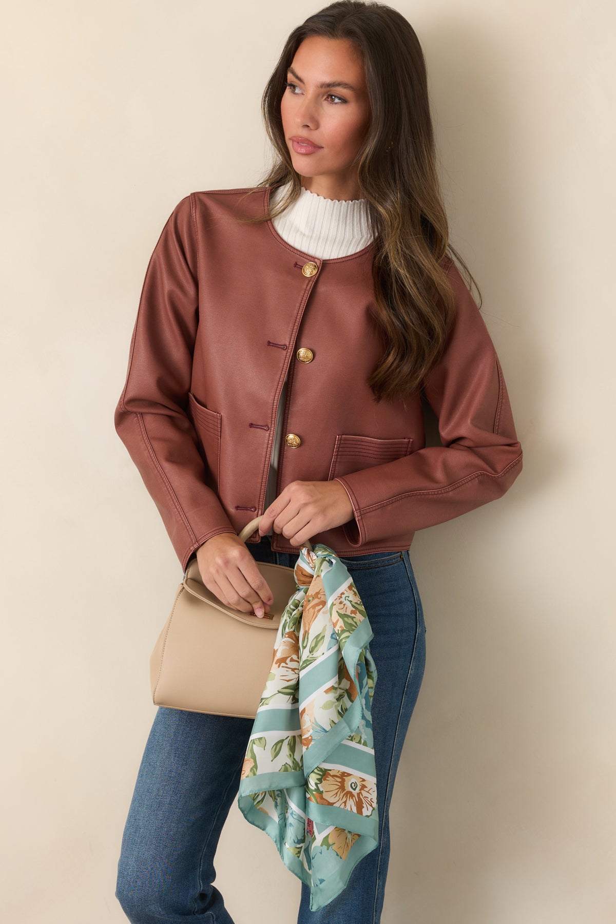 Front welt pockets and structured seams define the sleek silhouette of this mauve faux leather jacket.