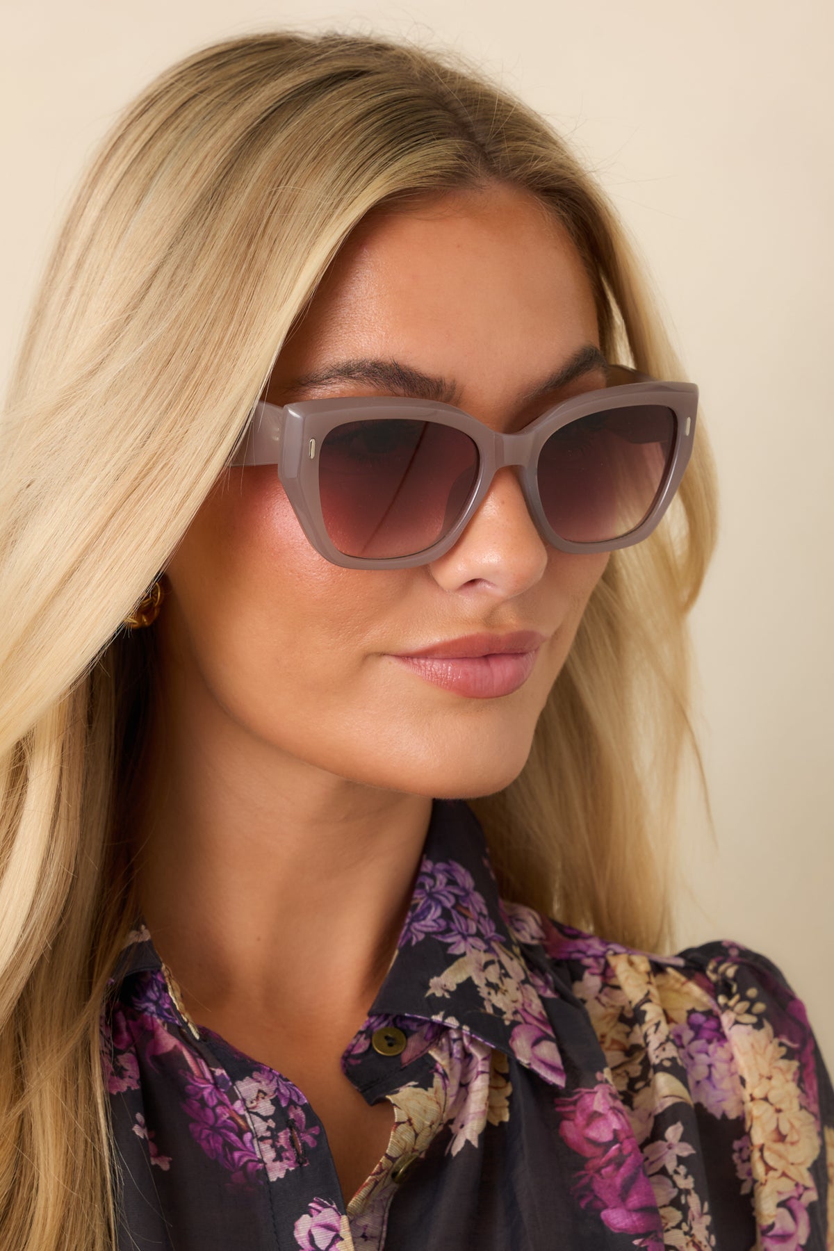 Close-up of the mauve taupe sunglasses’ glossy frames, brown gradient lenses, and small gold-tone accents.
