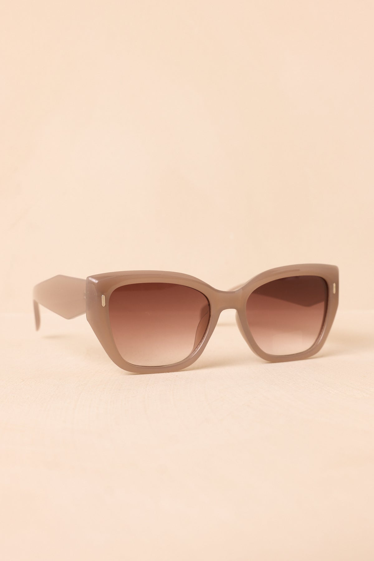 Mauve taupe sunglasses with oversized square frames and brown gradient lenses.