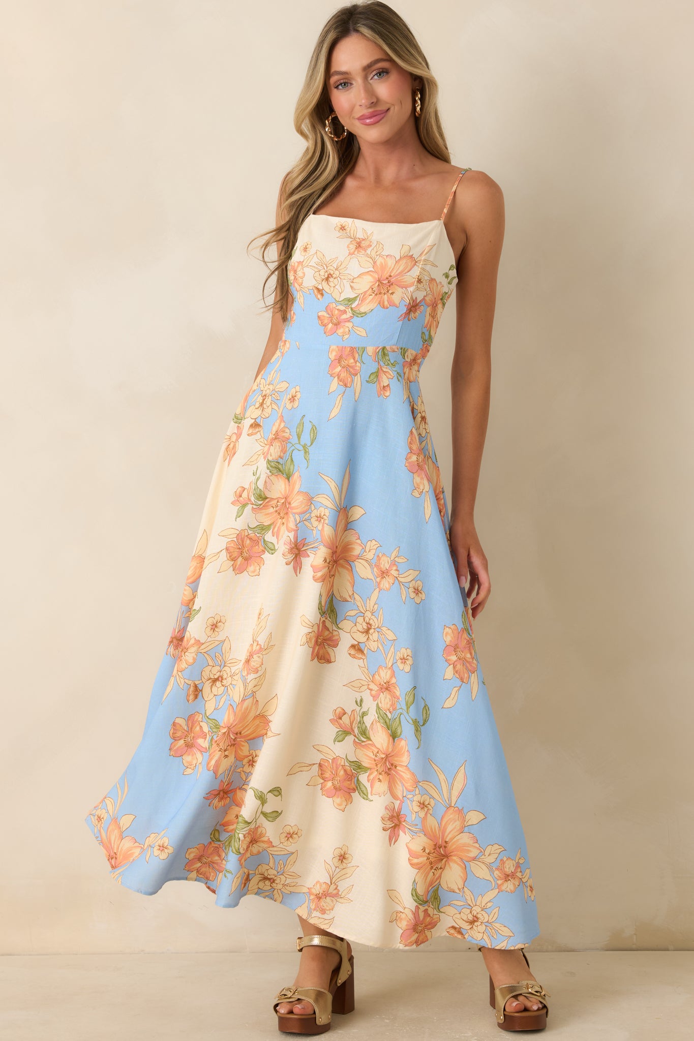 Blue and ivory maxi dress featuring a structured bodice that flows into a full-length skirt with feminine floral accents.