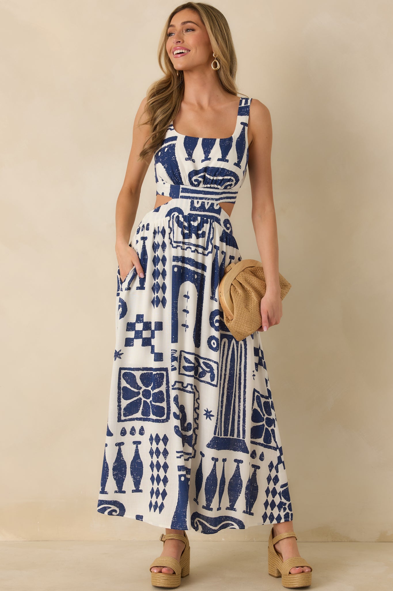 Two-tone maxi dress featuring side cut-out details, defined waist seam, and lightweight woven fabric.