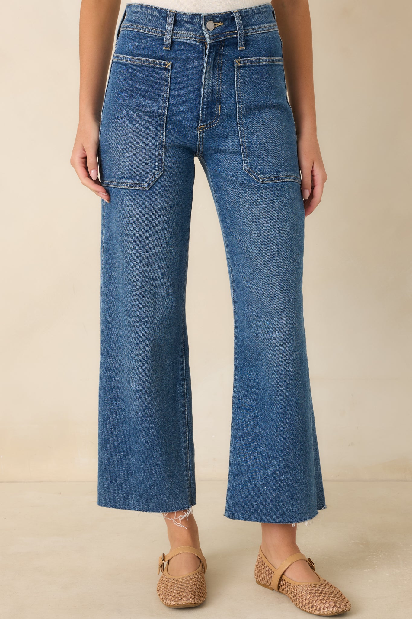 Medium wash denim featuring oversized front pockets, structured waistband, and wide-leg construction.