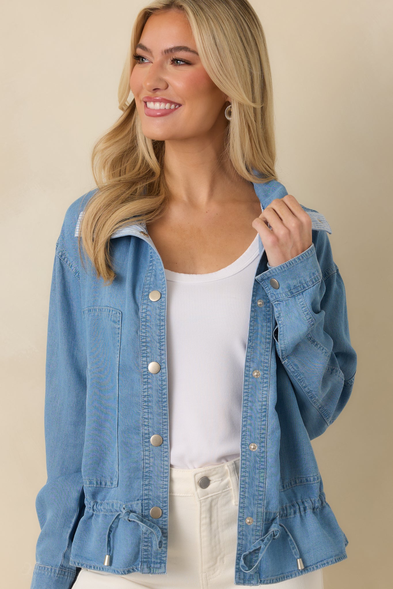 Medium wash fabric highlighting relaxed fit and silver snap closure.