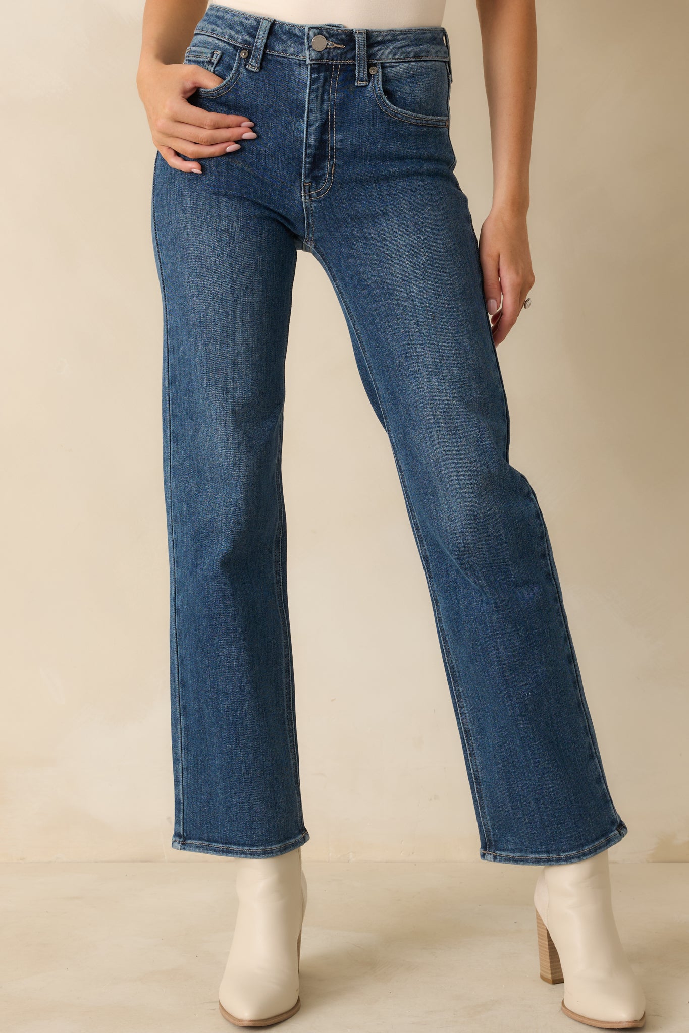 Medium wash high-rise jeans with a straight-leg silhouette, subtle fading along the thighs, and classic five-pocket styling.