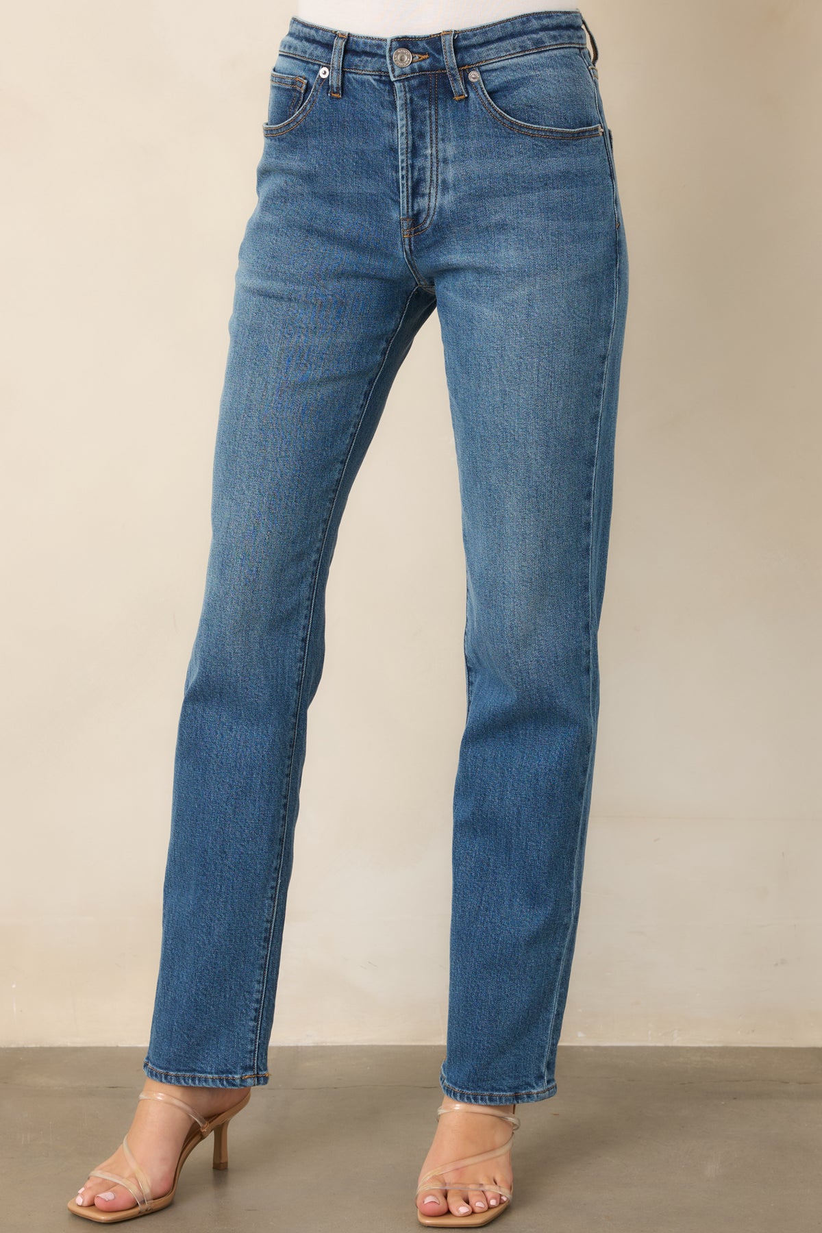 Medium wash jeans showcasing the button and zipper closure with belt loops.