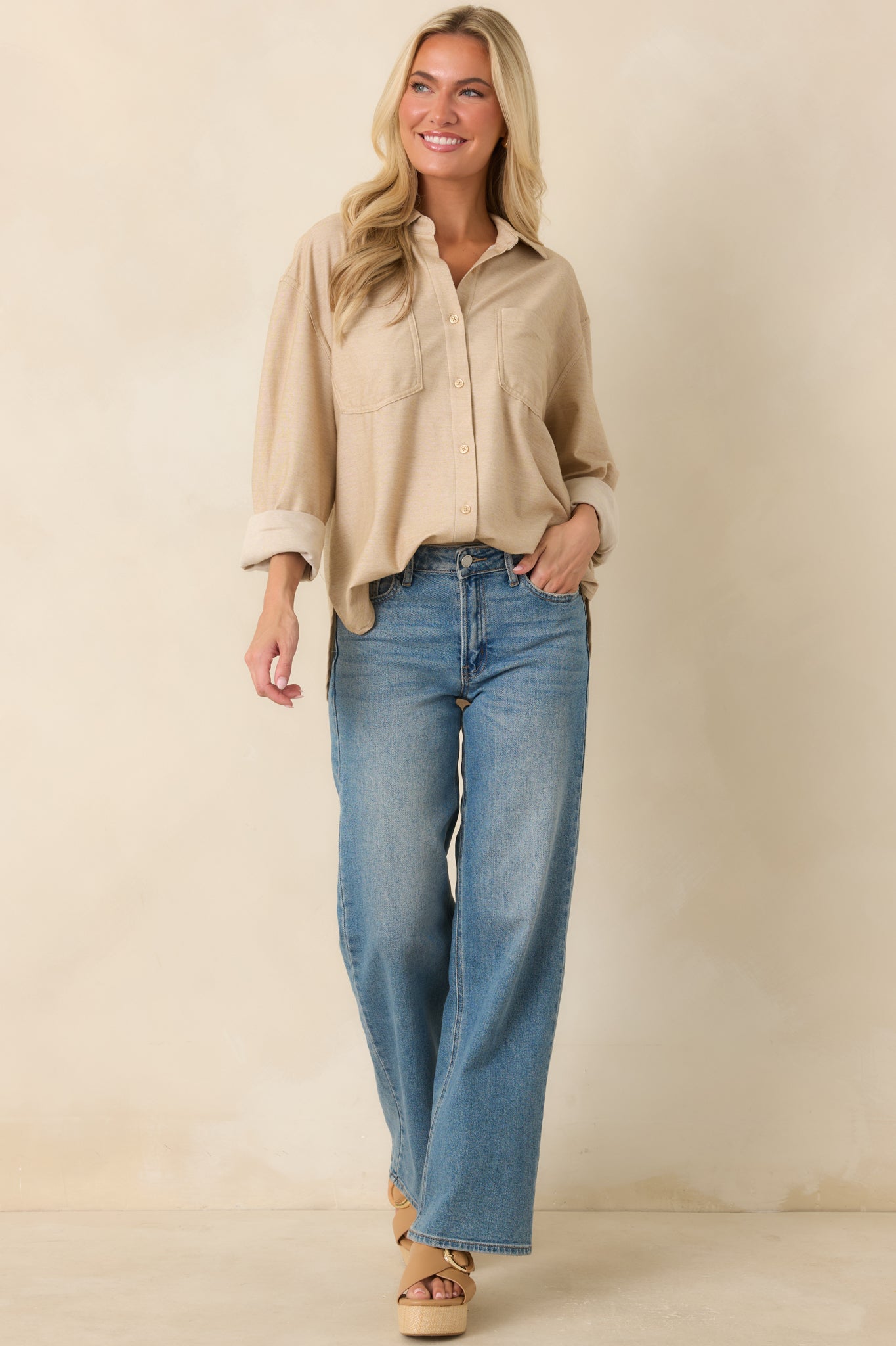 Medium wash jeans featuring a wide leg silhouette, functional belt loops, and a button zipper closure.