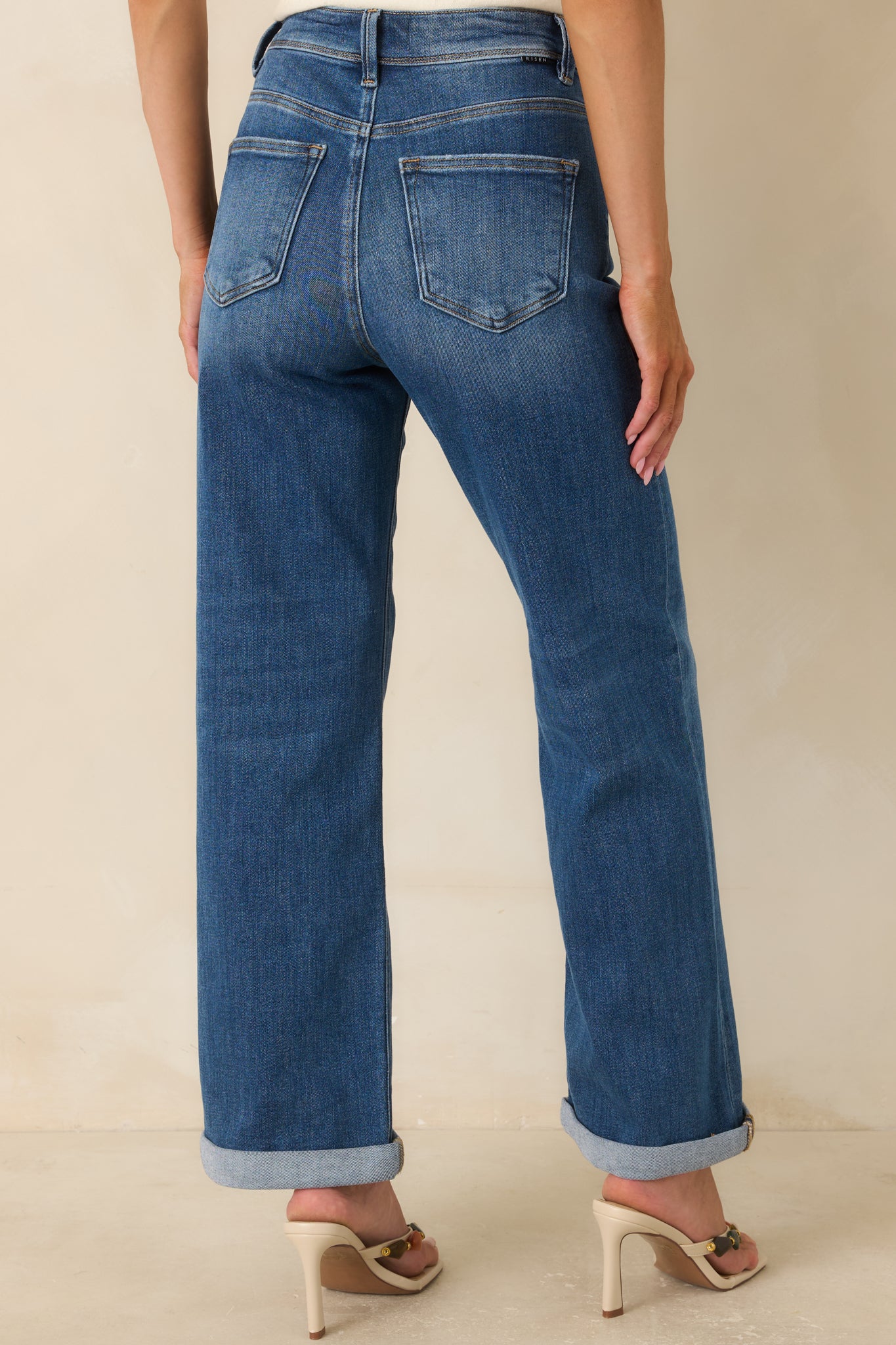 Rear view of the medium wash jeans featuring back pockets, high-rise waist, and relaxed straight-leg fit.
