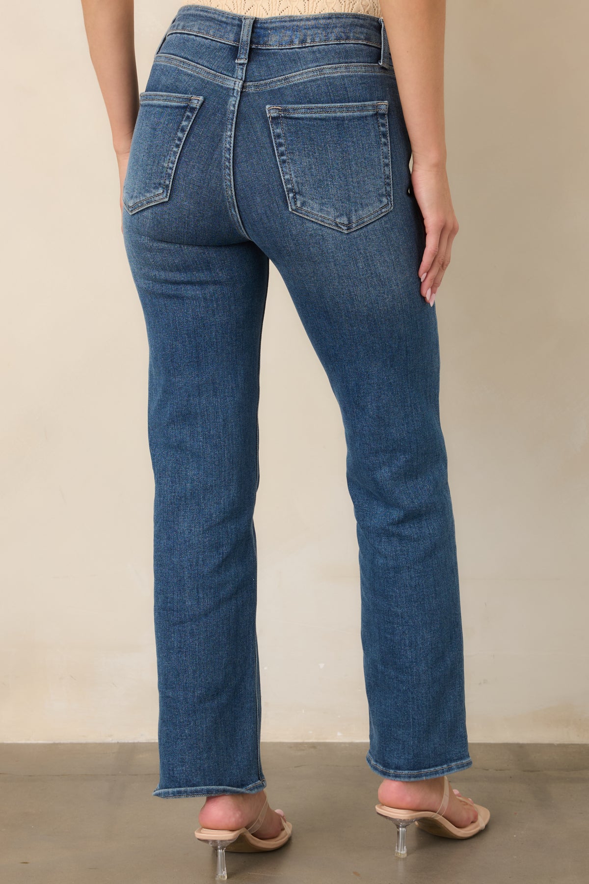 Rear view of the medium wash straight-leg jeans showcasing the high-rise waistband, two functional back pockets, subtle fading, and relaxed straight silhouette.