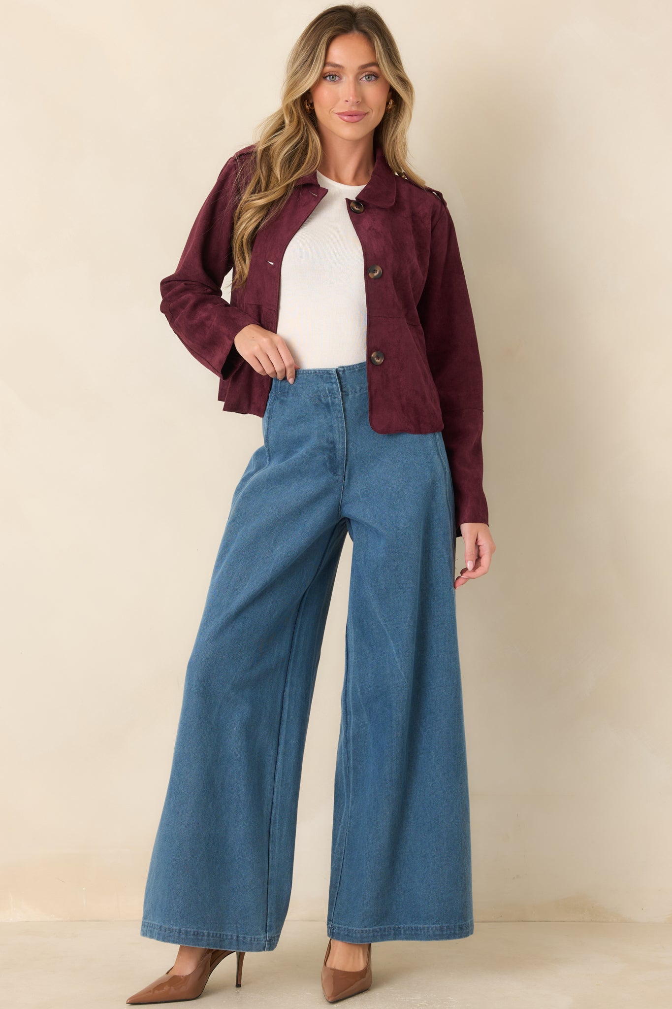 Medium wash wide leg jeans featuring a high-rise waist, hidden front zip closure, and curved scalloped side seams for a modern, flattering silhouette.