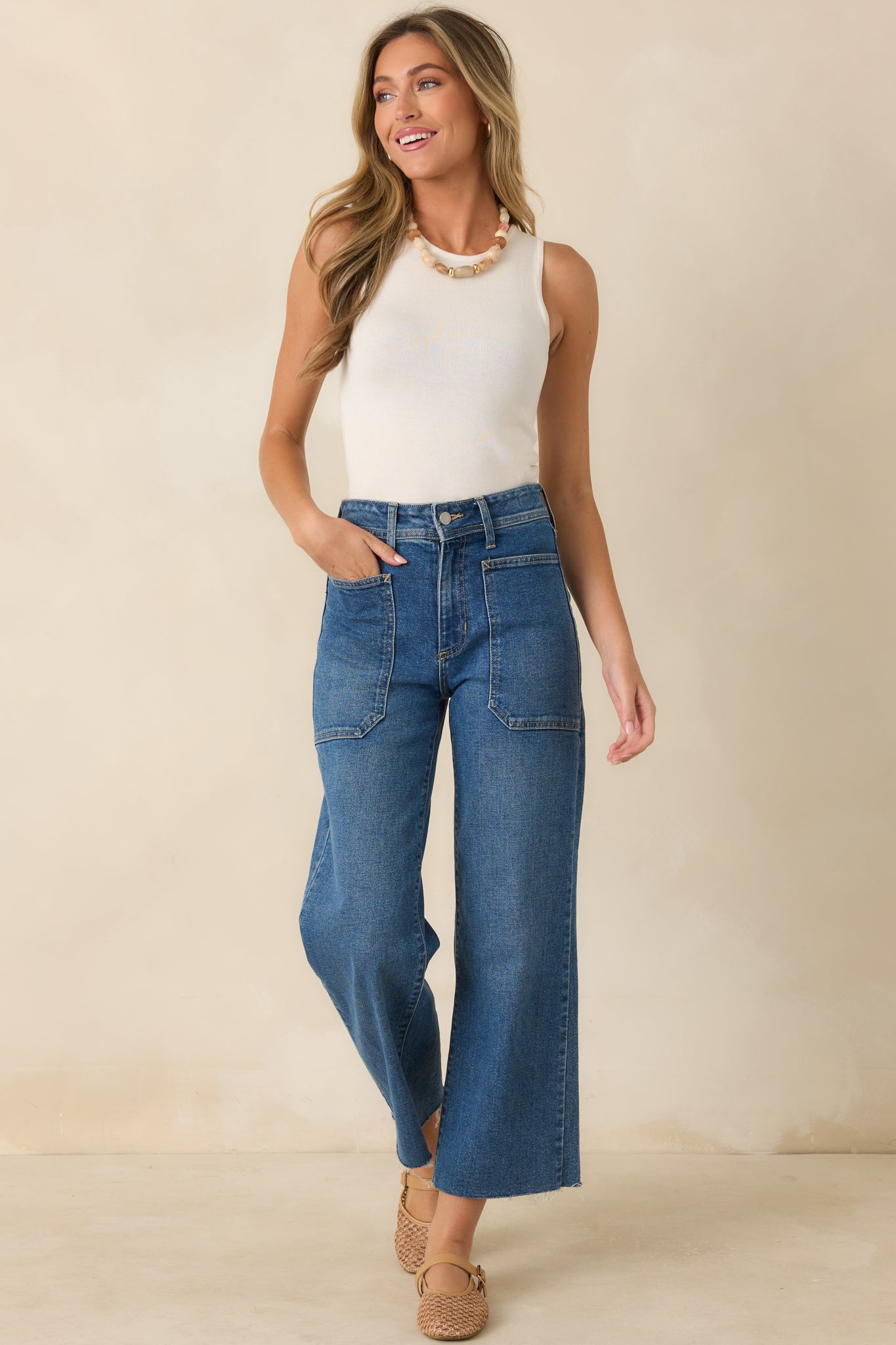 Medium wash wide-leg jeans with a structured high-rise waist, functional pockets, and unfinished hem detailing.