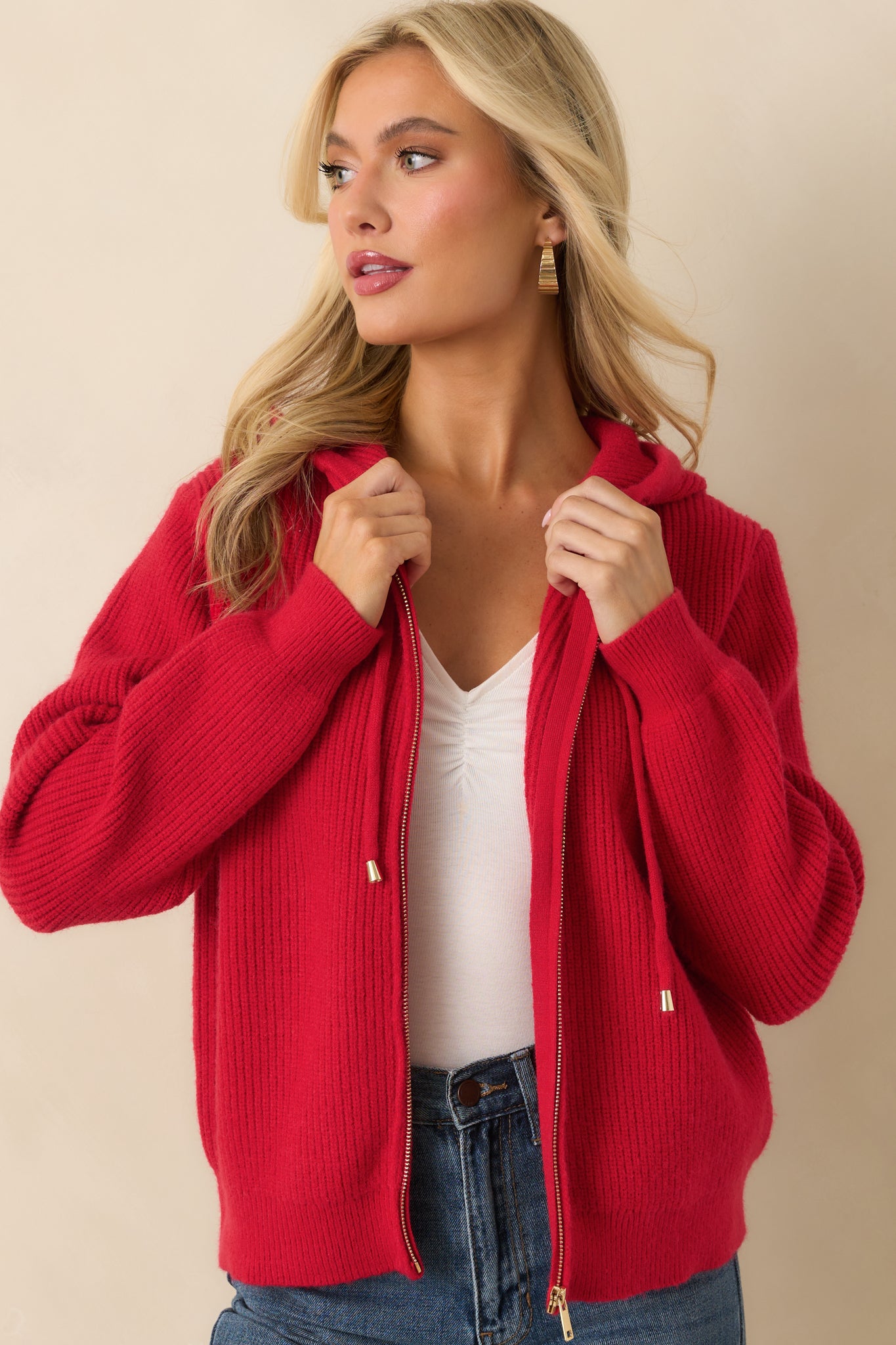 Mid-section look of the red jacket highlighting ribbed hem and long sleeve details.