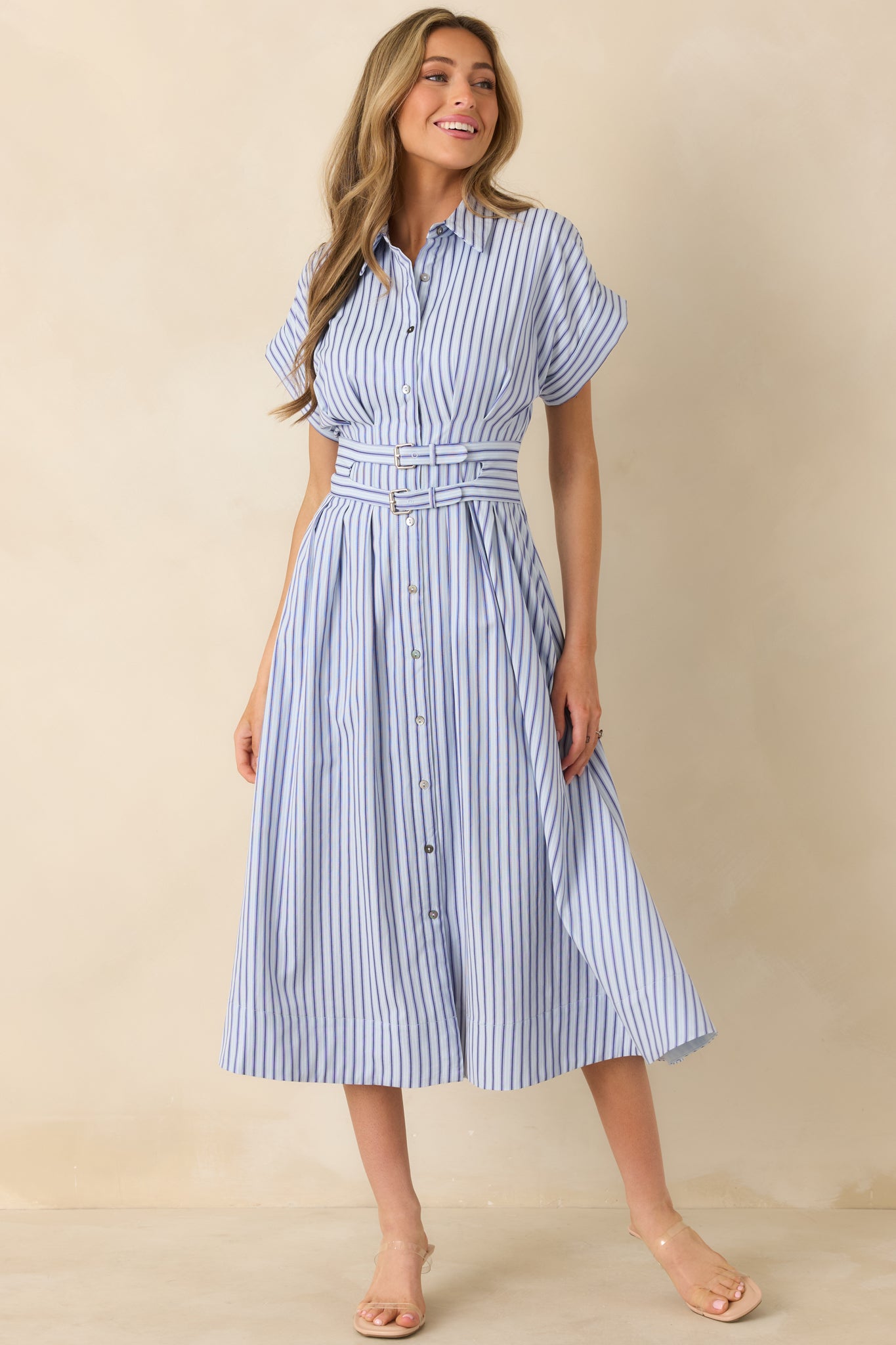 Midi-length blue dress with contrasting dark and light vertical striping, cuffed short sleeves, and a fixed front belt accent.