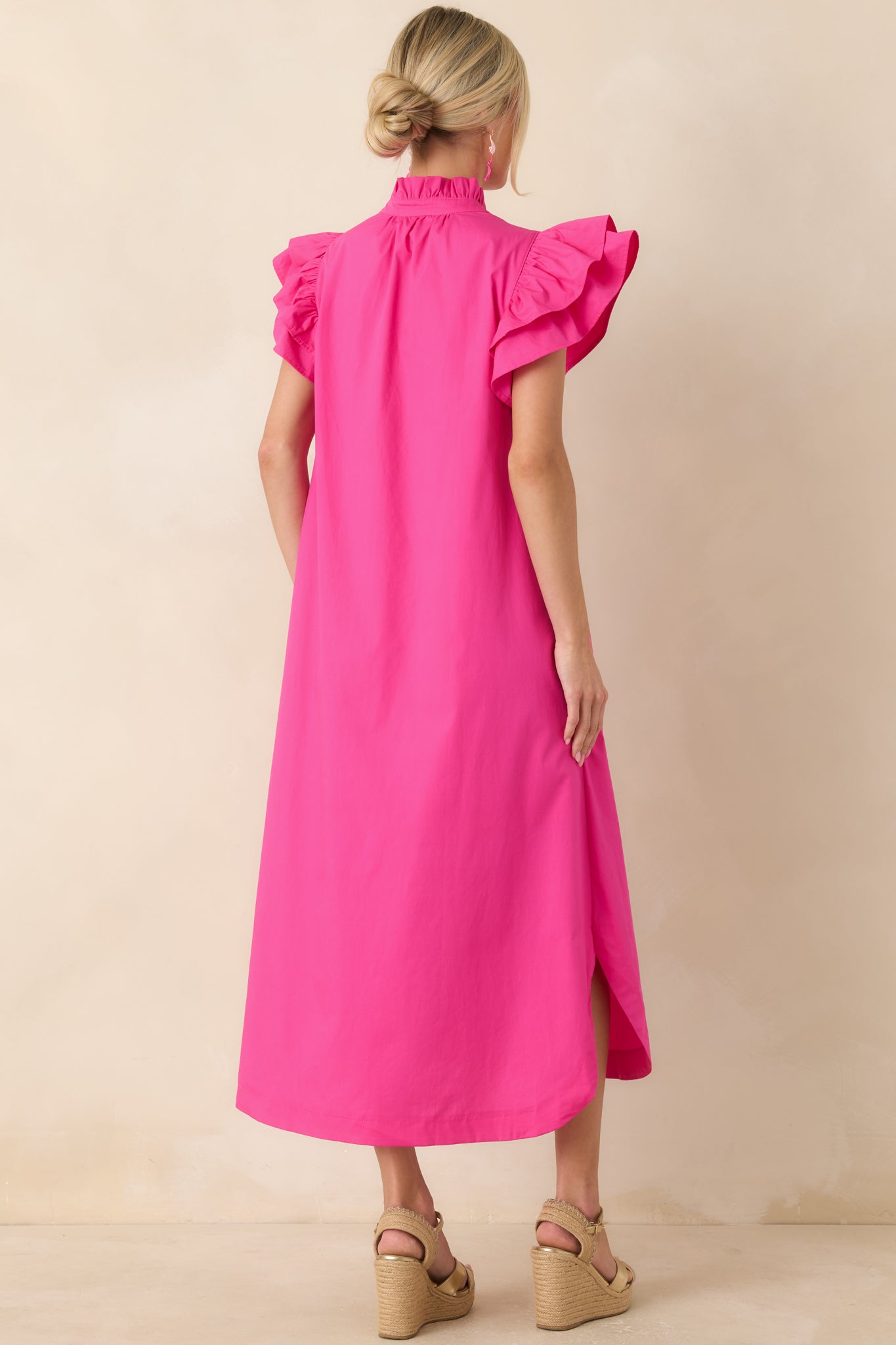 Back view of the cotton midi dress highlighting the flutter sleeves, relaxed fit, and curved hemline.
