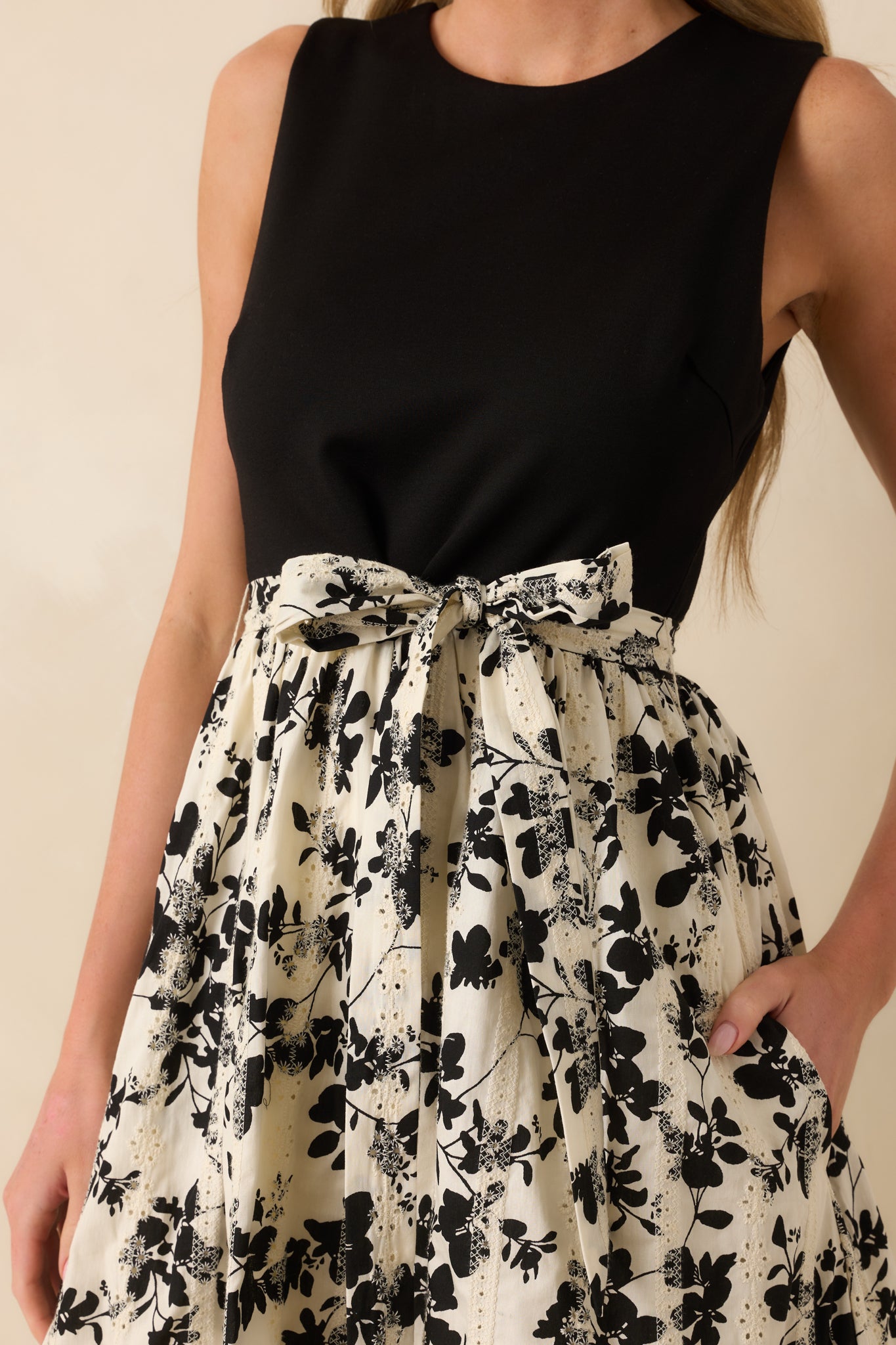Close-up of the round neckline, black bodice, and floral print skirt of the midi dress.