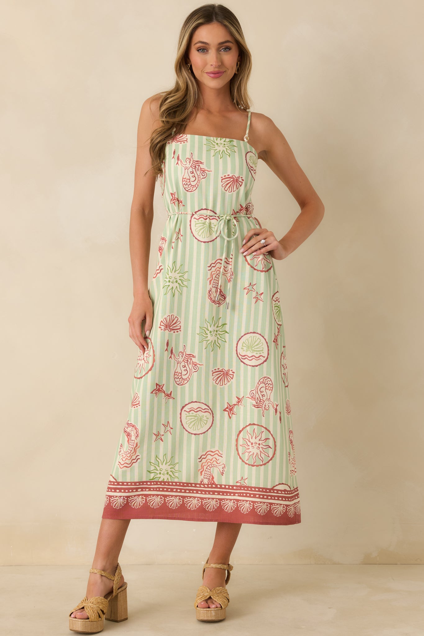 Lightweight midi dress highlighting adjustable spaghetti straps, soft flowing skirt, and whimsical printed pattern.