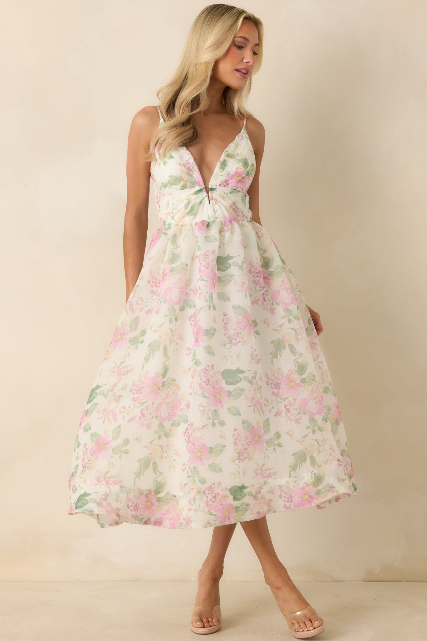 Romantic midi dress with adjustable straps and an allover floral print in soft ivory and pink tones.