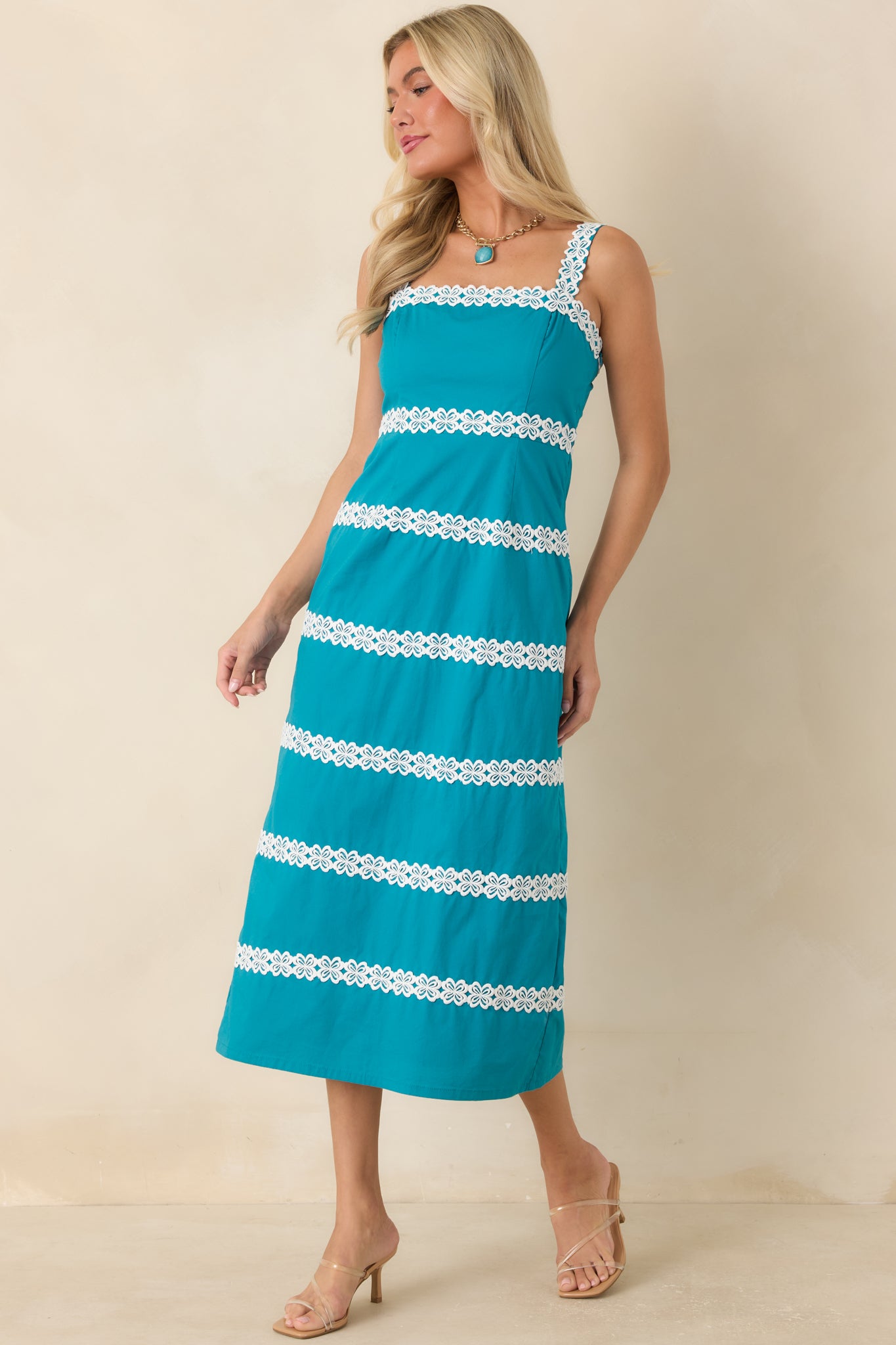 Midi dress featuring crisp contrast detailing, a smocked back, and elegant floral lace accents.