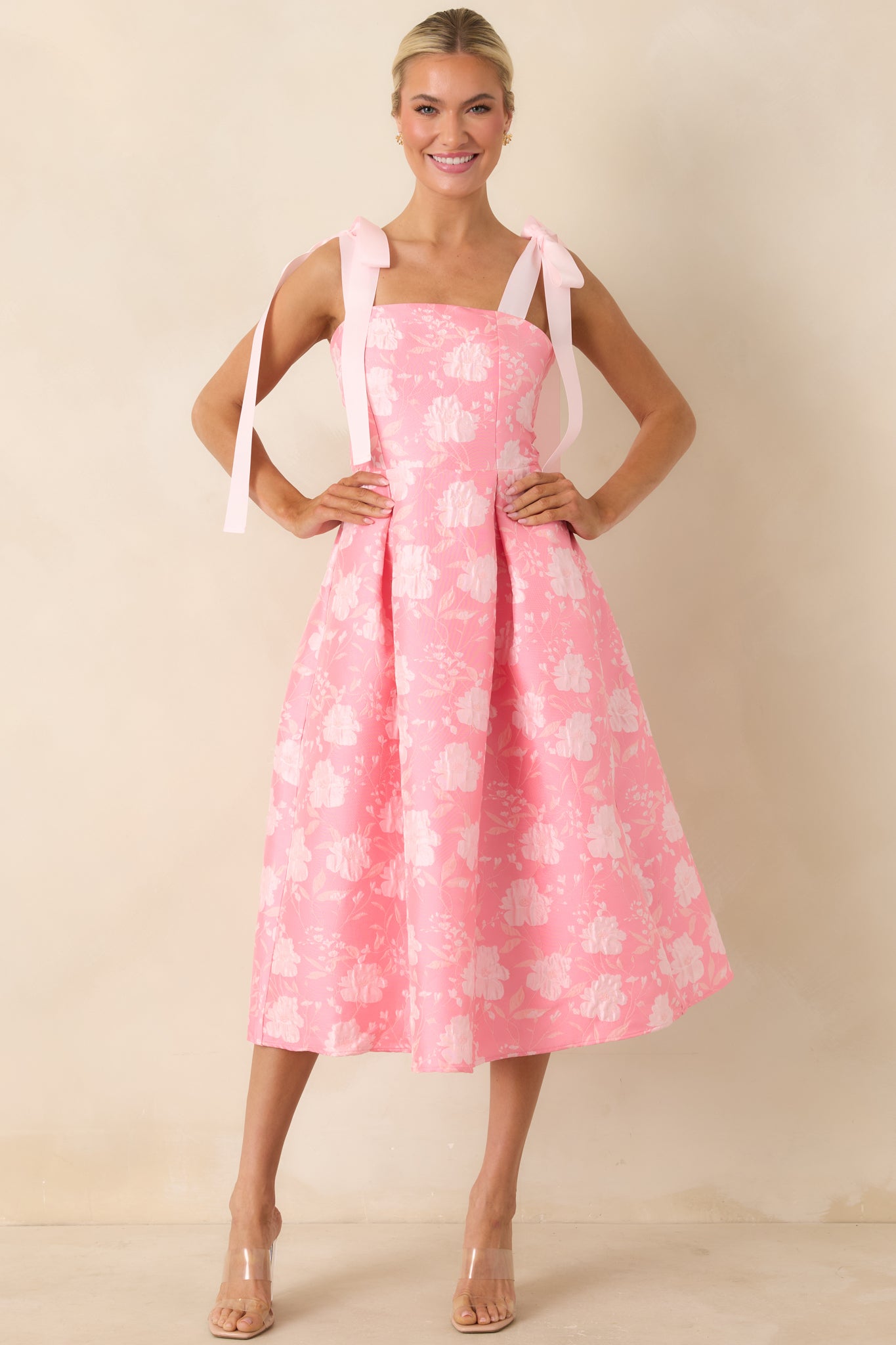 Midi dress with statement bow straps, fitted waist, and graceful full skirt shape.