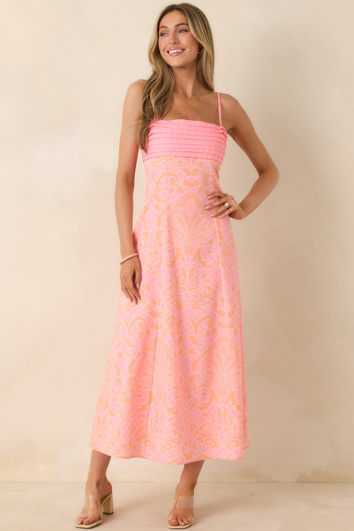 Midi-length pink and orange dress with a structured pleated bust and soft, airy silhouette for a comfortable fit