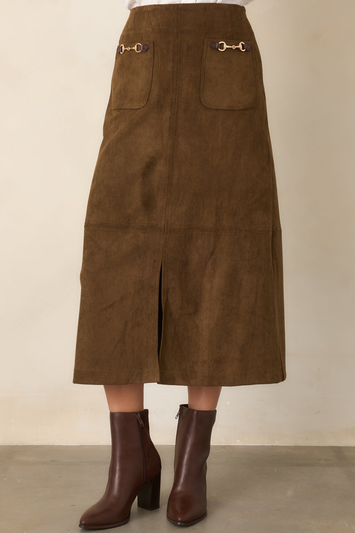 Midi skirt highlighting the high-rise waistband, functional front patch pockets, and decorative gold-tone accents.