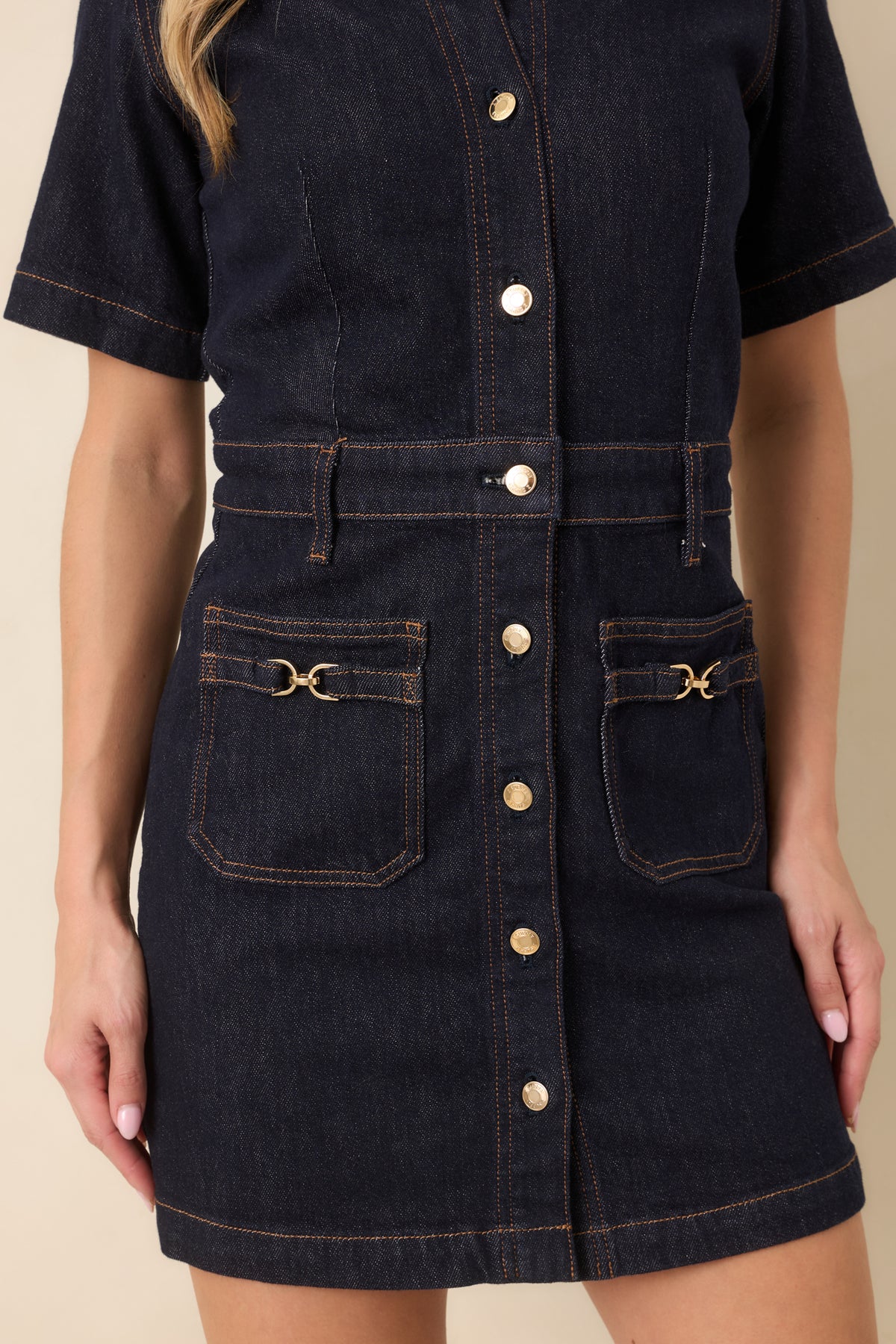 Close-up showcases the gold-tone buttons, denim texture, and decorative buckle accents on the front patch pocket.
