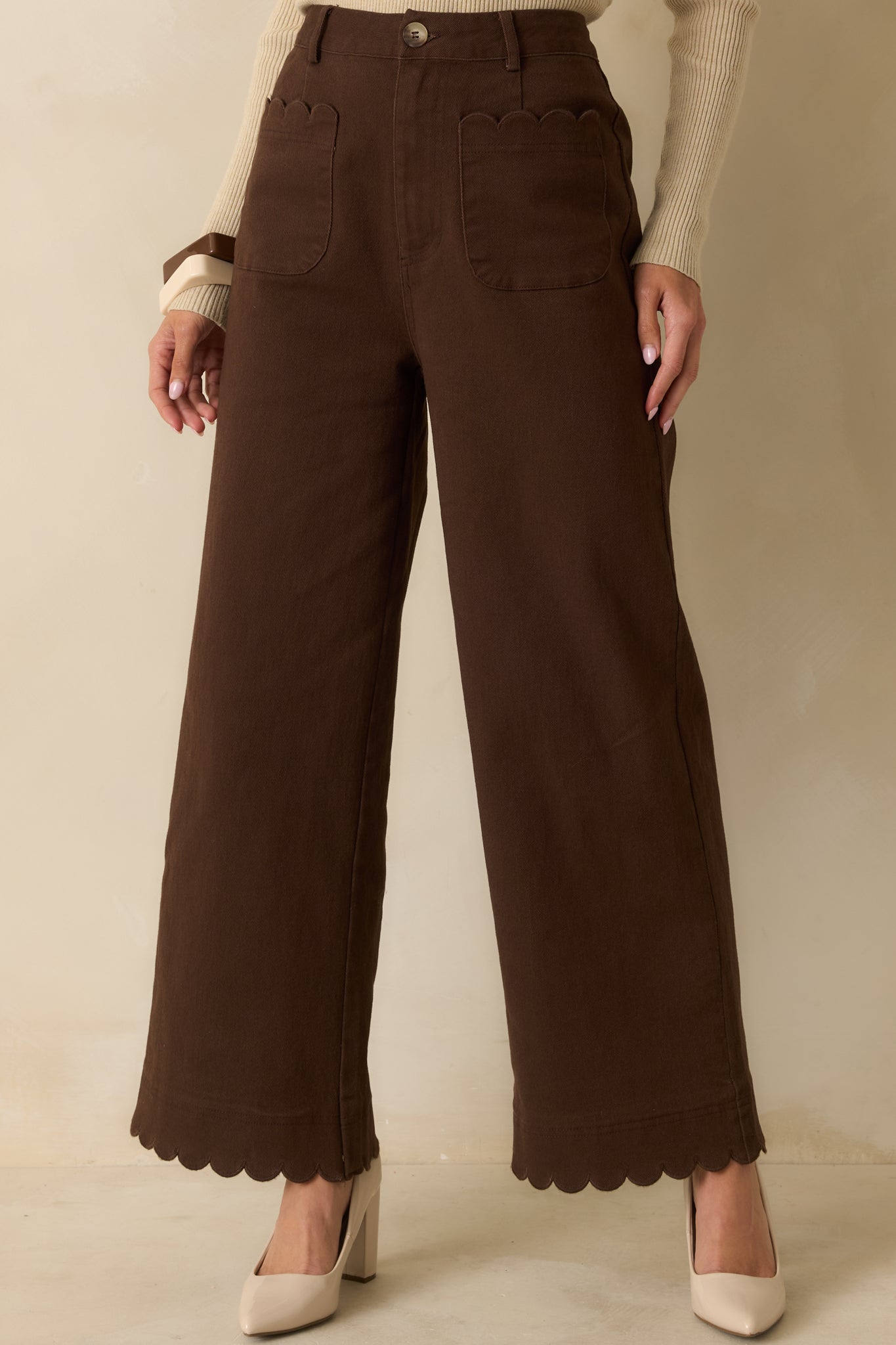 Midsection close-up highlighting structured fabric and scalloped detailing along front pockets.