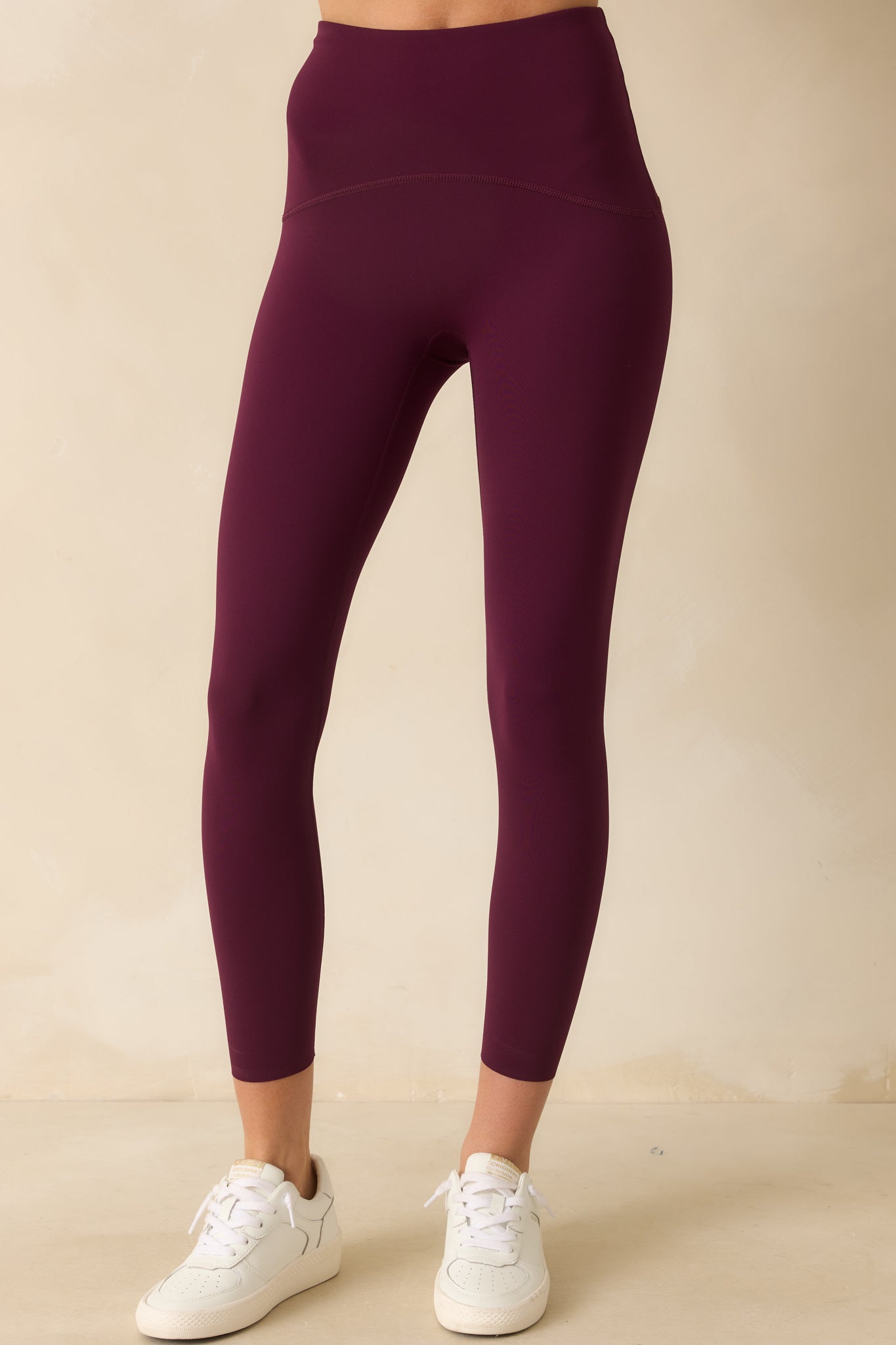 Focus on the midsection and hips, showing the tailored fit and subtle berry tone of the leggings.