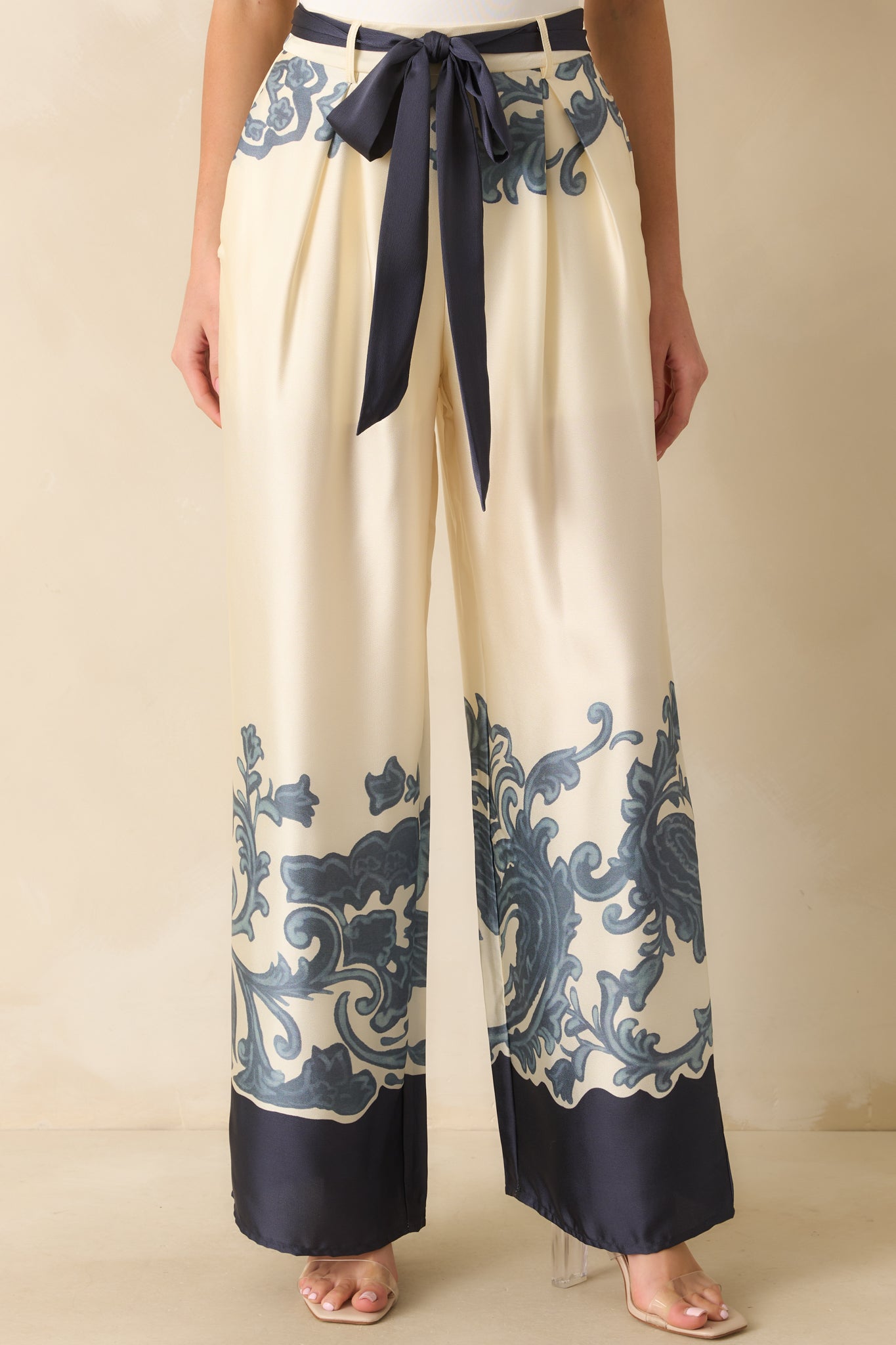 Midsection view highlighting the elastic back insert and functional front pockets on ivory fabric with navy print.