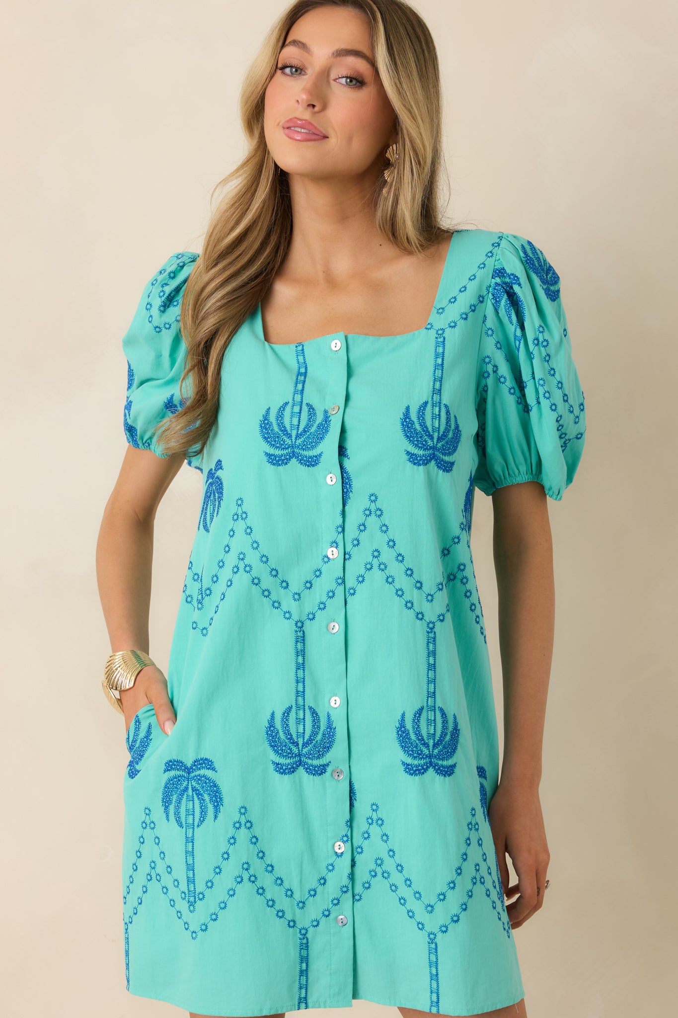 Mini dress detail showing side pockets and clean cotton construction.